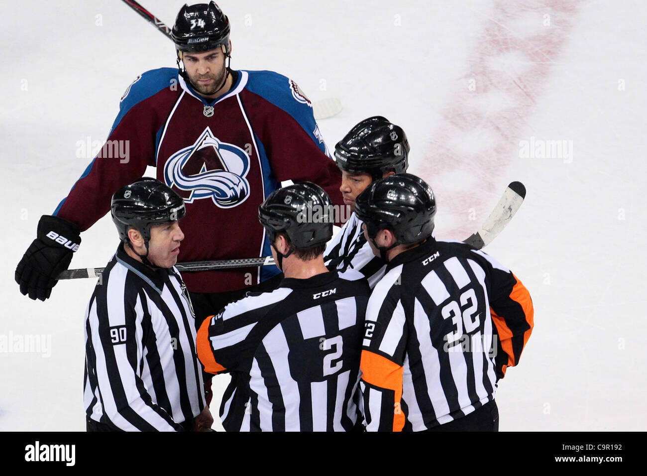 Feb. 10, 2012 - Denver, Colorado, United States - Colorado Avalanche left wing Daniel Winnik (34) listens in as linesman Andy McElman (90) talks with referee Tom Kowal (32) in the first period. After one period Carolina leads 2-1. The Colorado Avalanche hosted the Carolina Hurricanes at the Pepsi Ce Stock Photo