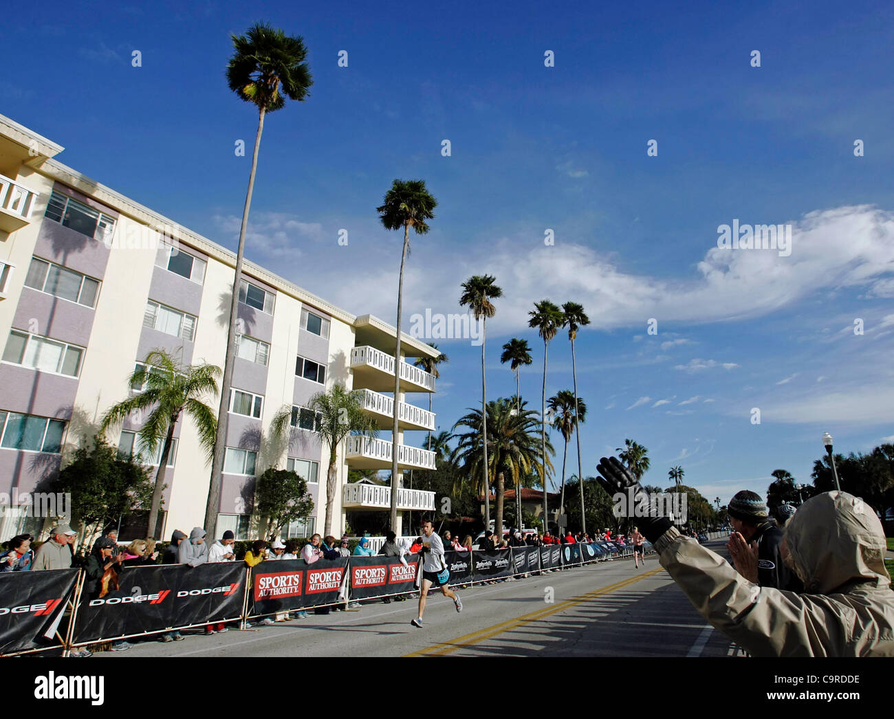 Onlookers wave and cheer as SEAN GALLAGHER of Clearwater, Florida, runs toward the finish line of the inaugural Rock 'n' Roll St. Pete Half Marathon. Gallagher finished 11th with an official time of 1:18:18. Stock Photo