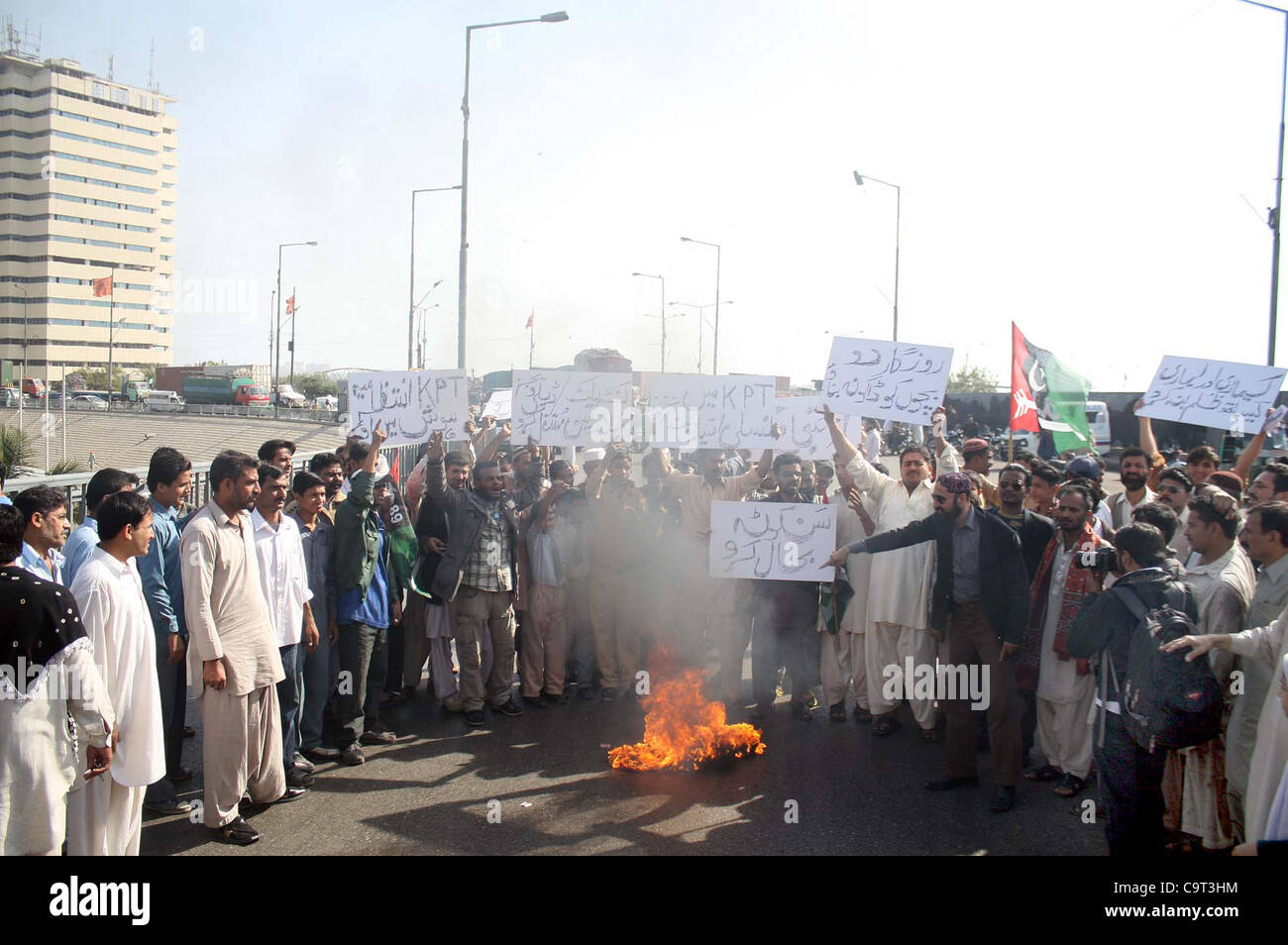 Supporters of Mutasireen Karachi Port Trust Forum gather near burning stuff during protest demonstration in favor of their demands at Jinnah Bridge in Karachi on Thursday, February 16, 2012. Stock Photo