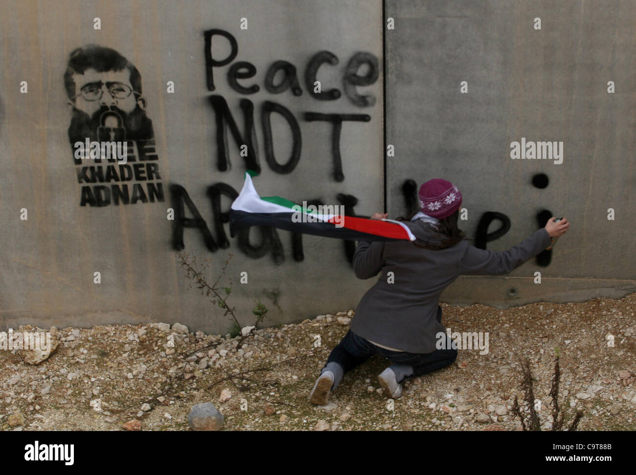 Feb. 17, 2012 - Billin, West Bank - Palestinian activists spray paint a picture of Khader Adnan onto the separation barrier during a protest calling for the release of the prisoner Khader Adnan, one of the leaders of the militant Islamic Jehad Movement. He has reportedly been on a hunger strike for  Stock Photo