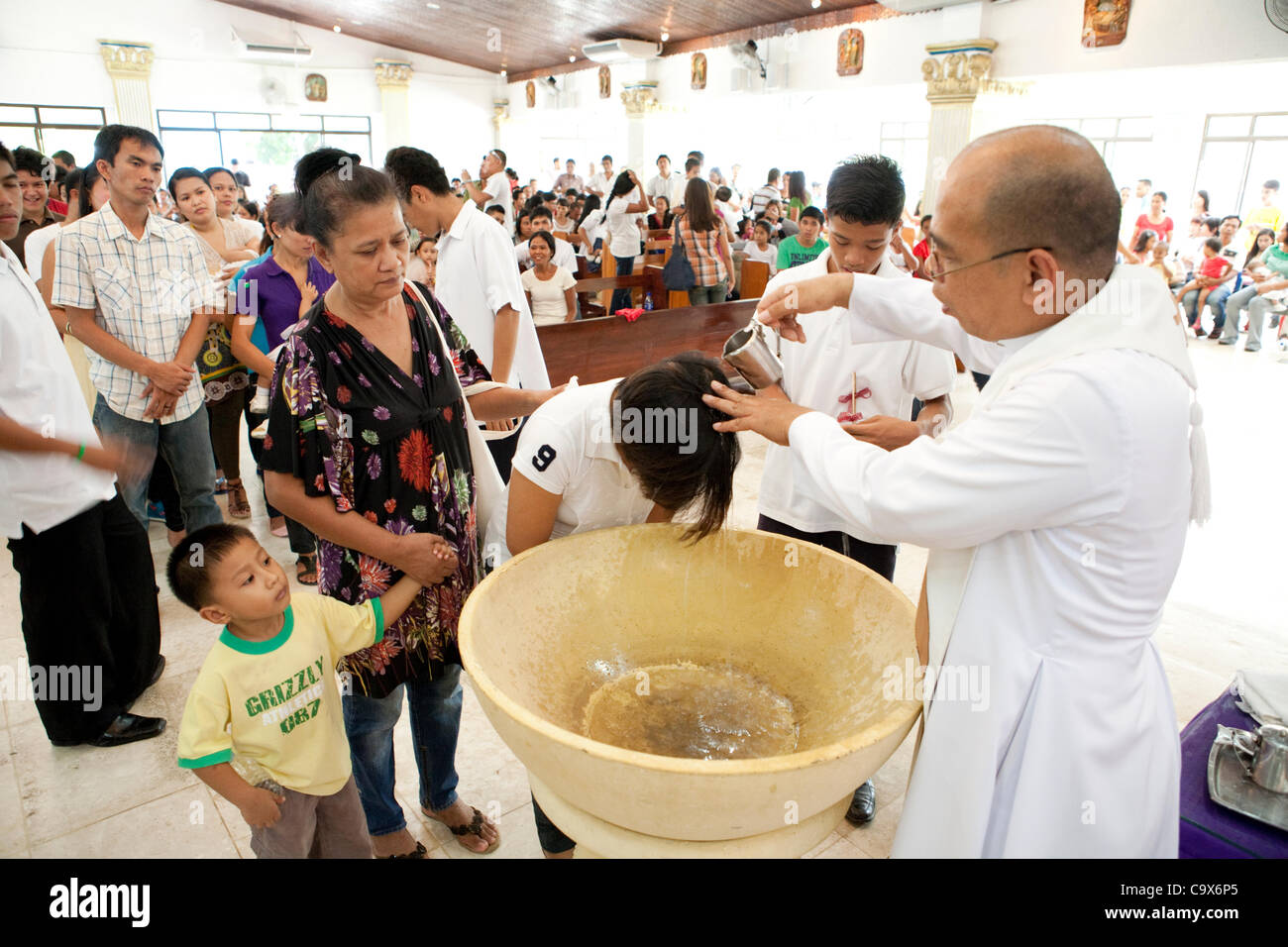Lapu-Lapu City, Philippines, 26/02/2012:  200-300 babies and a few adults being baptised in a single 3 hour ceremony at Mactan Air Base Chapel. Stock Photo