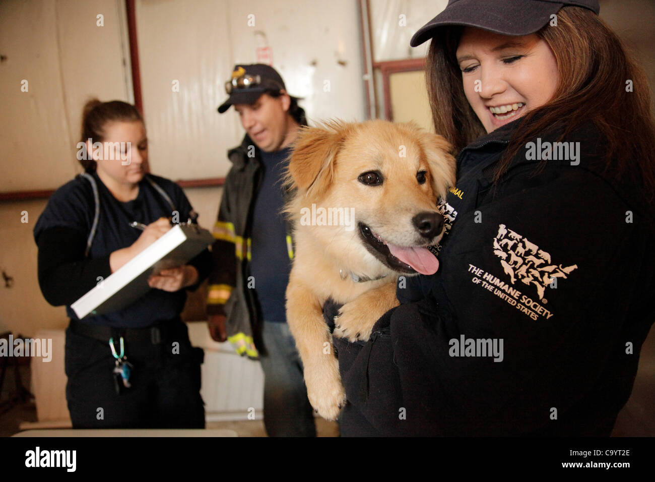 March 9, 2012 - London, Kentucky, USA - Operations chief Julie Casteneda comforts a stray dog which was just brought into The Humane Society of the United States' emergency animal shelter by Brandon Zacharias, center, a member of the East Bernstadt Fire Department, in the aftermath of tornados that  Stock Photo