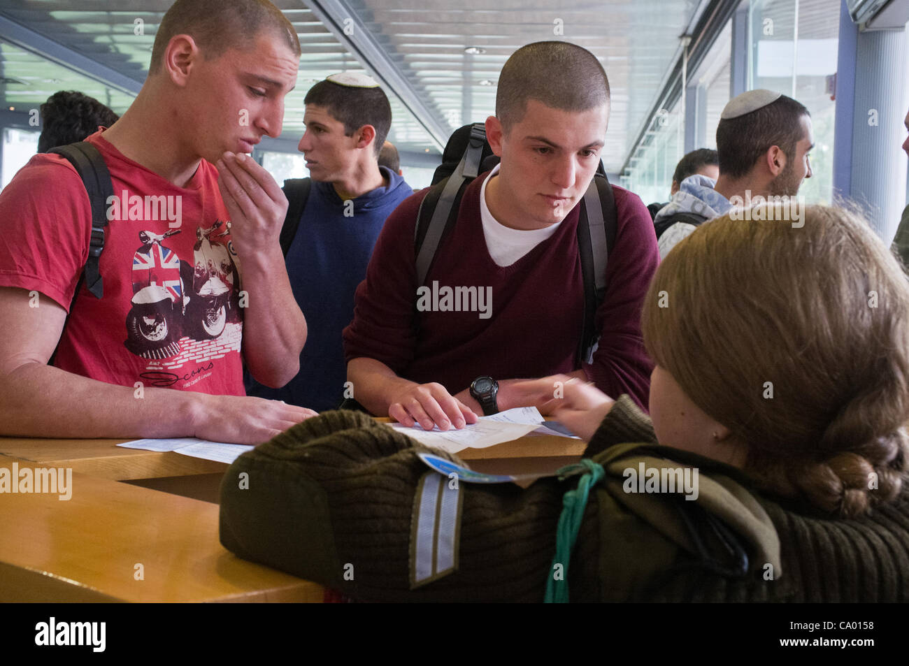 Nadav Paldi (maroon sweater), 20, is drafted into IDF at Ammunition Hill Recruitment Center. Nadav will begin basic training for an elite infantry unit attached to the Golani Brigade and serve for at least three years. Jerusalem, Israel. 11-Mar-2012. Stock Photo