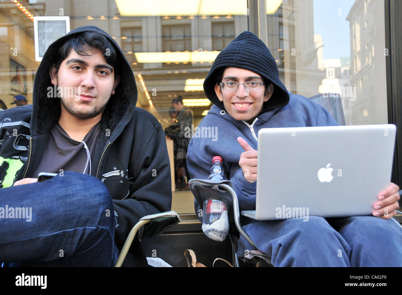 Regent Street London 11/3/12. The queue for iPad 3 starts nearly a week before its launch outside the Apple store on Regent Street. Zohaib is first in the queue [right] and his friend Ali [left]. Stock Photo