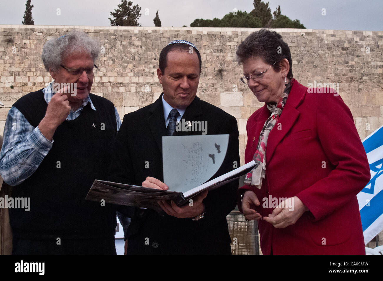 Jerusalem Mayor Mr. Nir Barkat (C) and Deputy Mayor Ms. Naomi Tsur (R) receive a book on ornithology from Dr. Yossi Leshem (L), of the Tel-Aviv University and Society for the Protection of Nature. Jerusalem, Israel. 12-Mar-2012. Stock Photo
