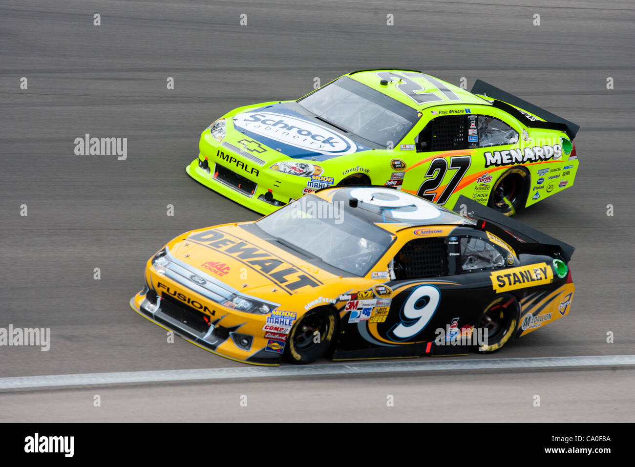 March 11, 2012 - Las Vegas, Nevada, U.S - Marcos Ambrose, driver of the #9 Dewalt Ford Fusion, keeps down on the line to avoid a crash while Paul Menard, driver of the #27 Schrock / Menards Chevrolet Impala, tries to keep off of him during the exciting racing action at the NASCAR Sprint Cup Series K Stock Photo
