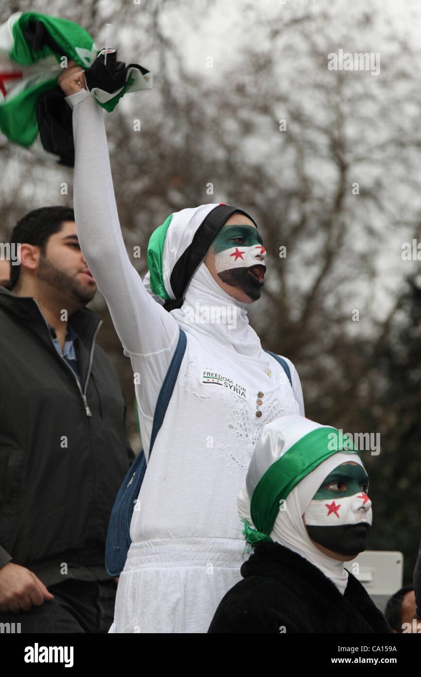 LONDON, UK, 17th March 2012. An anti Assad protester shouts and waves the Syrian flag during the demonstration outside their embassy. Hundreds of Syrians marched from Paddington Green to the embassy with flags and placards on the anniversary of the uprising. Stock Photo