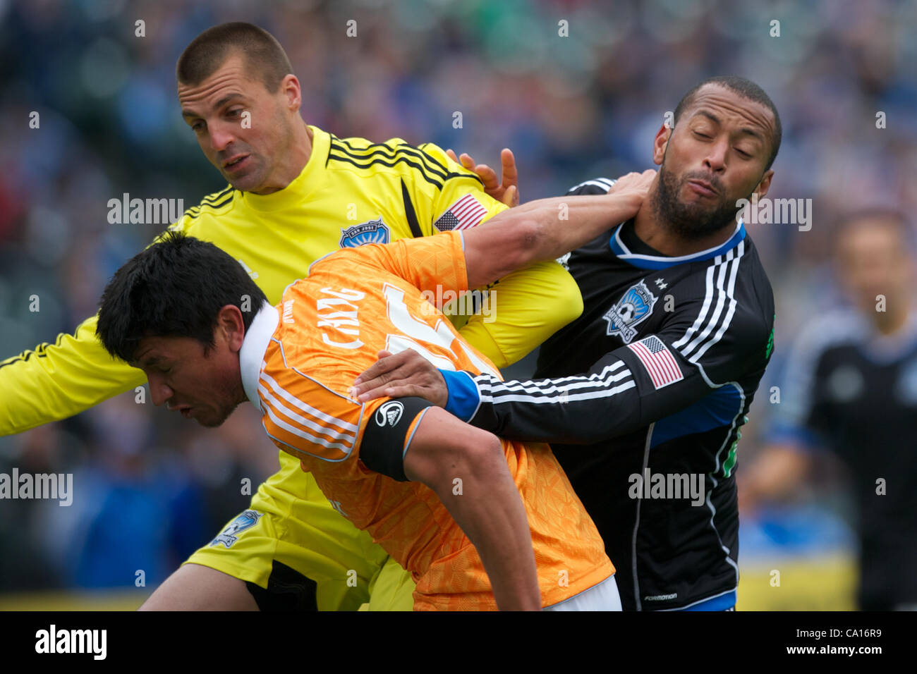 March 17, 2012 - San Francisco, California, U.S - Earthquakes goalkeeper Jon Busch (18) and defender Victor Bernardez (26) foul Dynamo forward Brian Ching (25) in the box during the MLS match between the San Jose Earthquakes and Houston Dynamo at AT&T Park in San Francisco, CA.  The Dynamo lead 1-0  Stock Photo