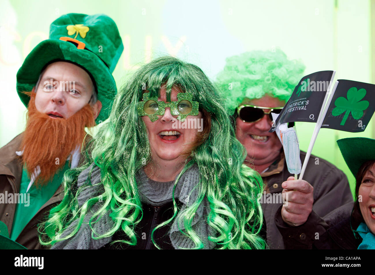 Fans waving flags and wearing a green wig on the parade route of the St