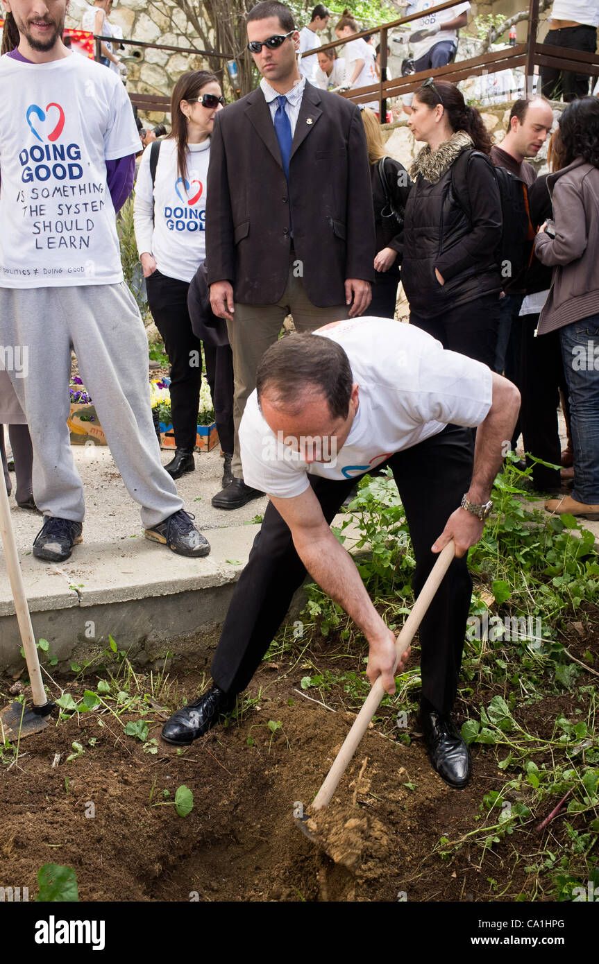 Mayor Nir Barkat hoes to plant a tree in a community garden on Stern ...