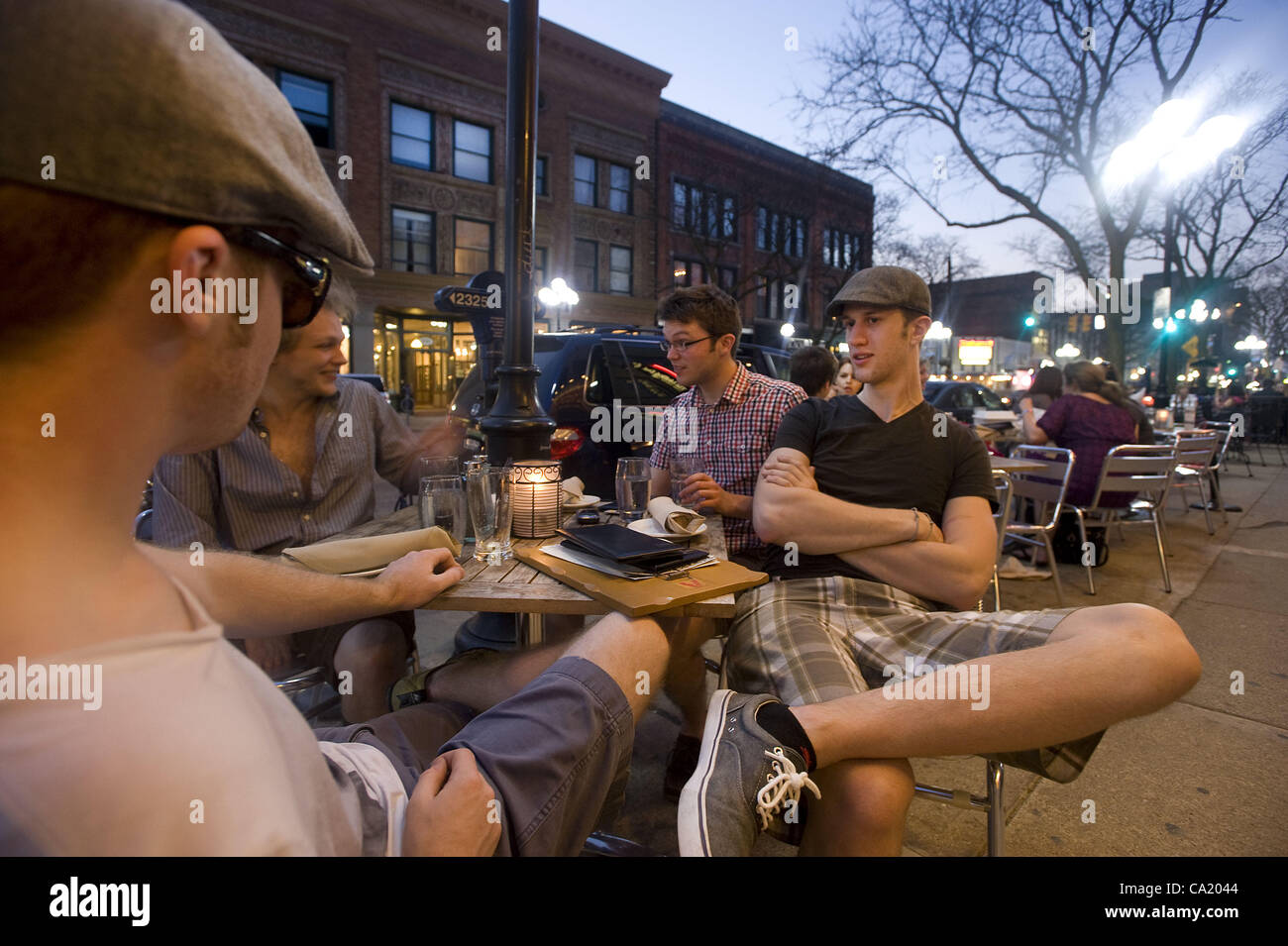March 21, 2012 - Ann Arbor, Michigan, U.S - From left, Kevin Mckinney, Floyd Cheeseman, Matt Peckhan, and Henry Rensch relax outside the Jolly Pumpkin bar and restaurant on Main Street in downtown Ann Arbor, MI on March 21, 2012.  Temperatures in the low 80s brought large crowds of people out to din Stock Photo