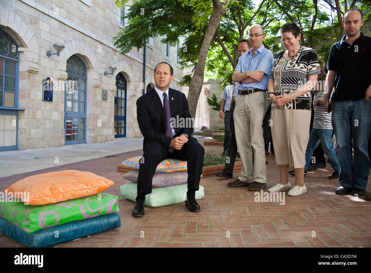 Mayor Nir Barkat sits on concrete, but very life-like cushions, part of an art installation by designer Smadar Carmeli, at Kikar Safra City Hall Square. Jerusalem, Israel. 31-May-2012. Stock Photo