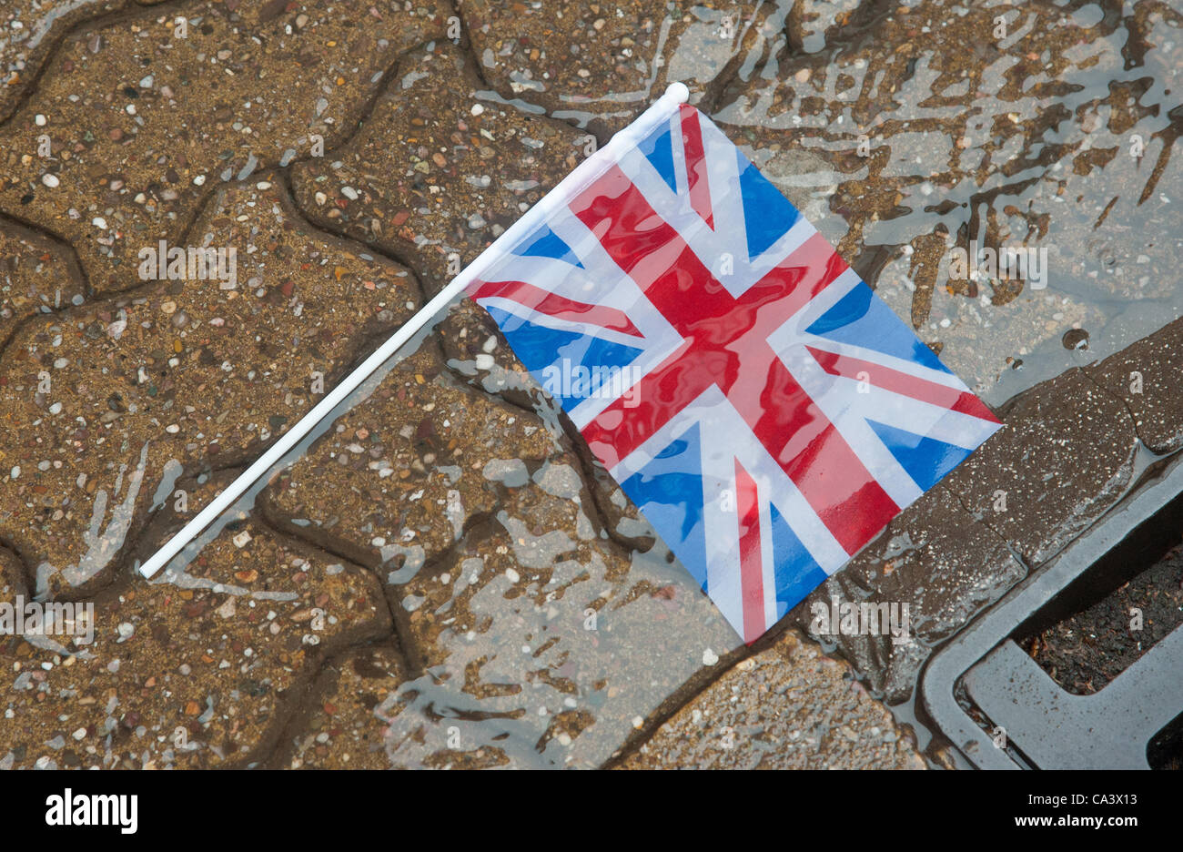 Jubilee Celebrations, Redditch , Worcestershire. Wet weather hit  Jubilee Celebrations across the Midlands, picture shows a Union Jack flag being washed away during a downpour in Redditch Town Centre. Stock Photo