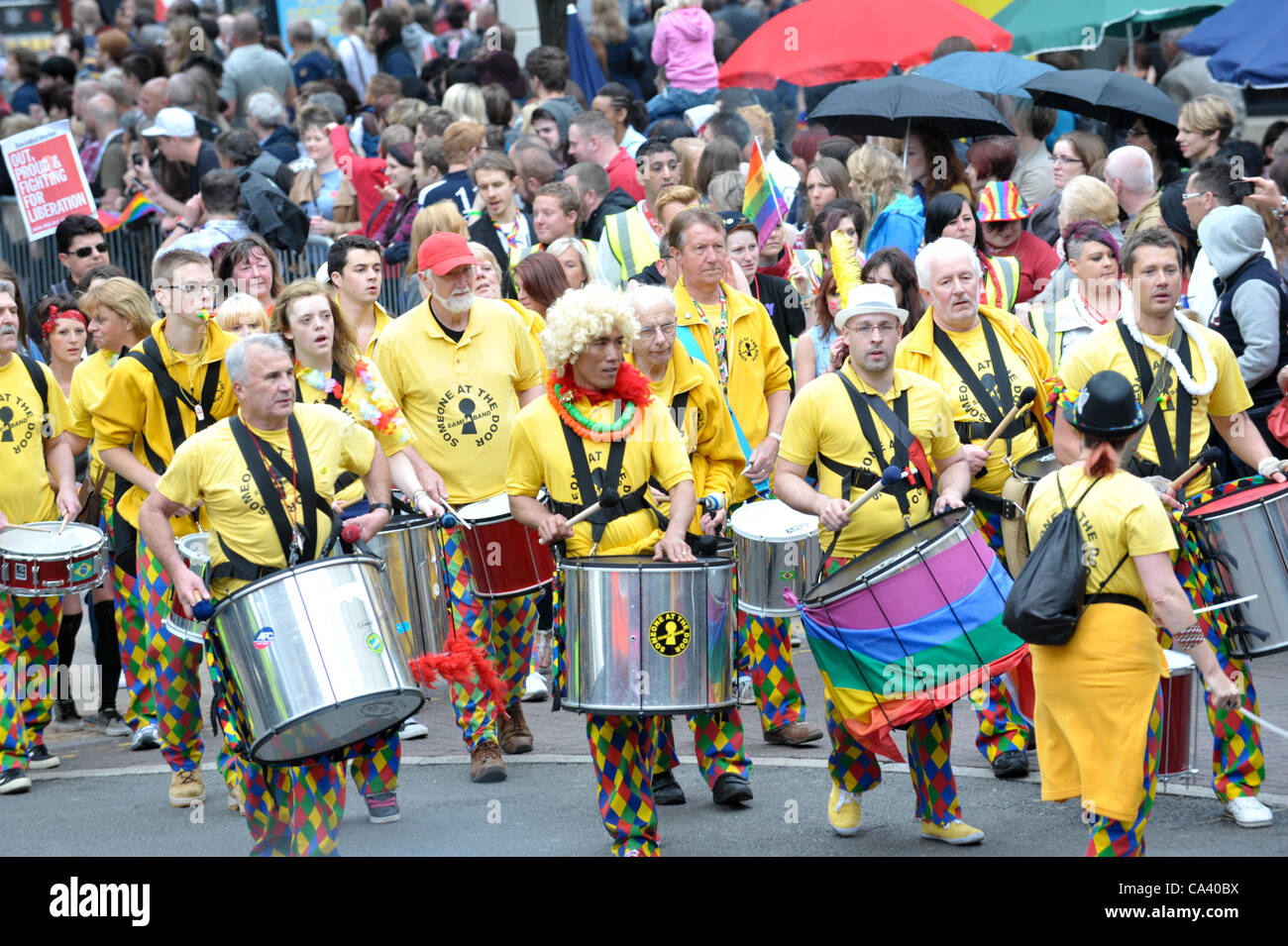 Marching Samba band in yellow t shirts drum and walk past crowds ...