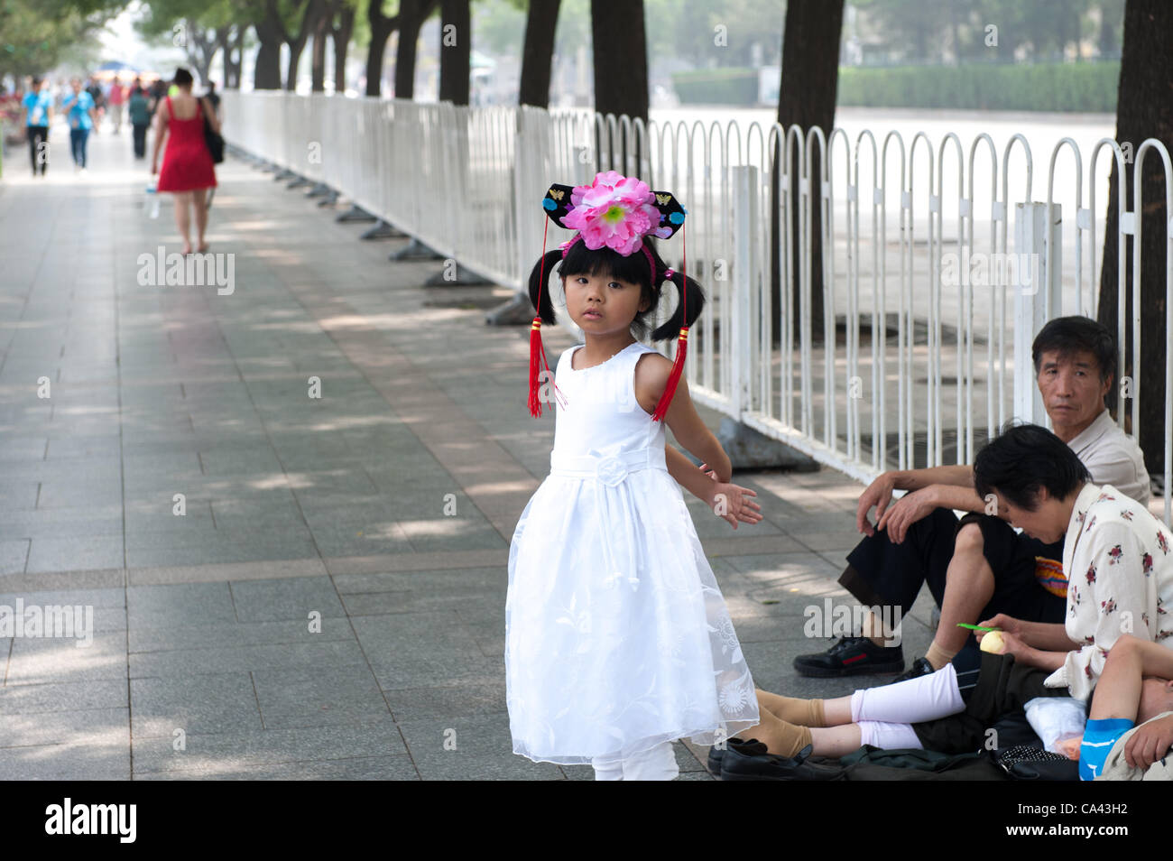 Girl wearing traditional clothes visiting Tiananmen Square with her family, Beijing, China on Monday June 4, 2012. June 4th 2012 marks the 23rd anniversary of the military crackdown on students protests at Tiananmen Square in 1989. Stock Photo