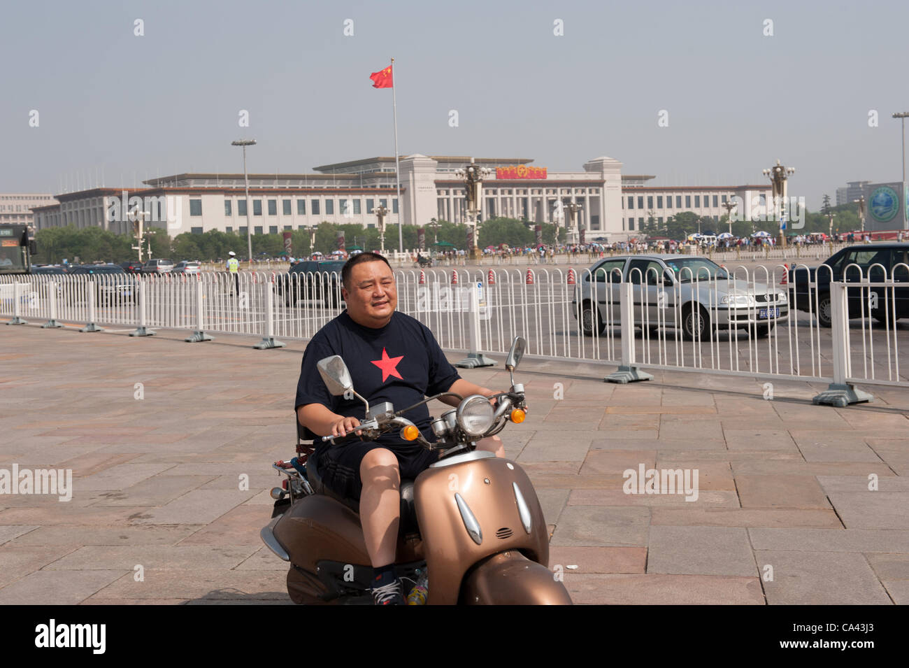 Man driving on a scooter at Tiananmen Square, Beijing, China on Monday June 4, 2012. June 4th 2012 marks the 23rd anniversary of the military crackdown on students protests at Tiananmen Square in 1989. Stock Photo