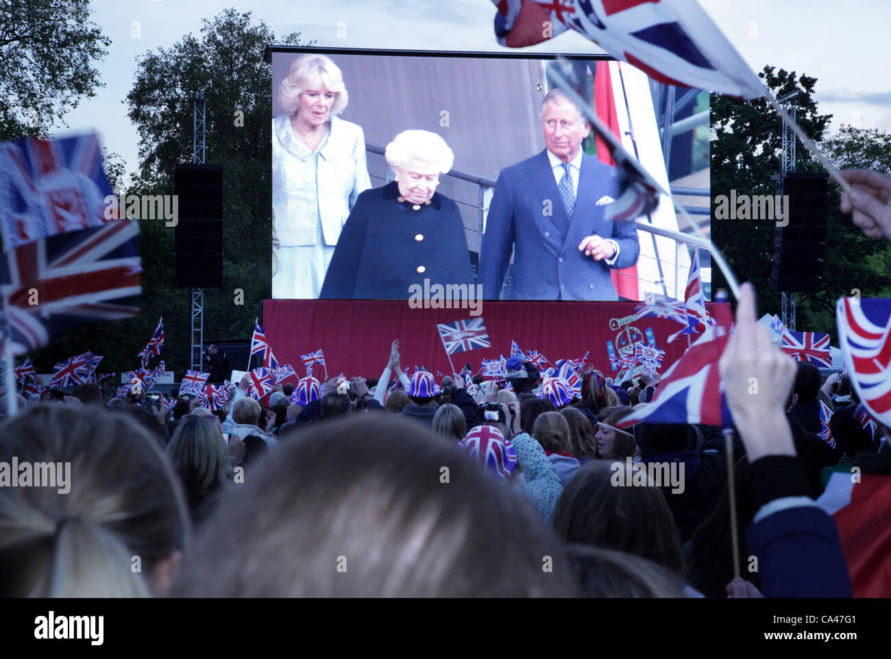 London, UK. June 4, 2012. Fans in St. James's Park, London. Watch on the big screens as The Queen, arrive at the Diamond Jubilee concert , with The Price of Wales and The Duchess of Cornwall. Stock Photo