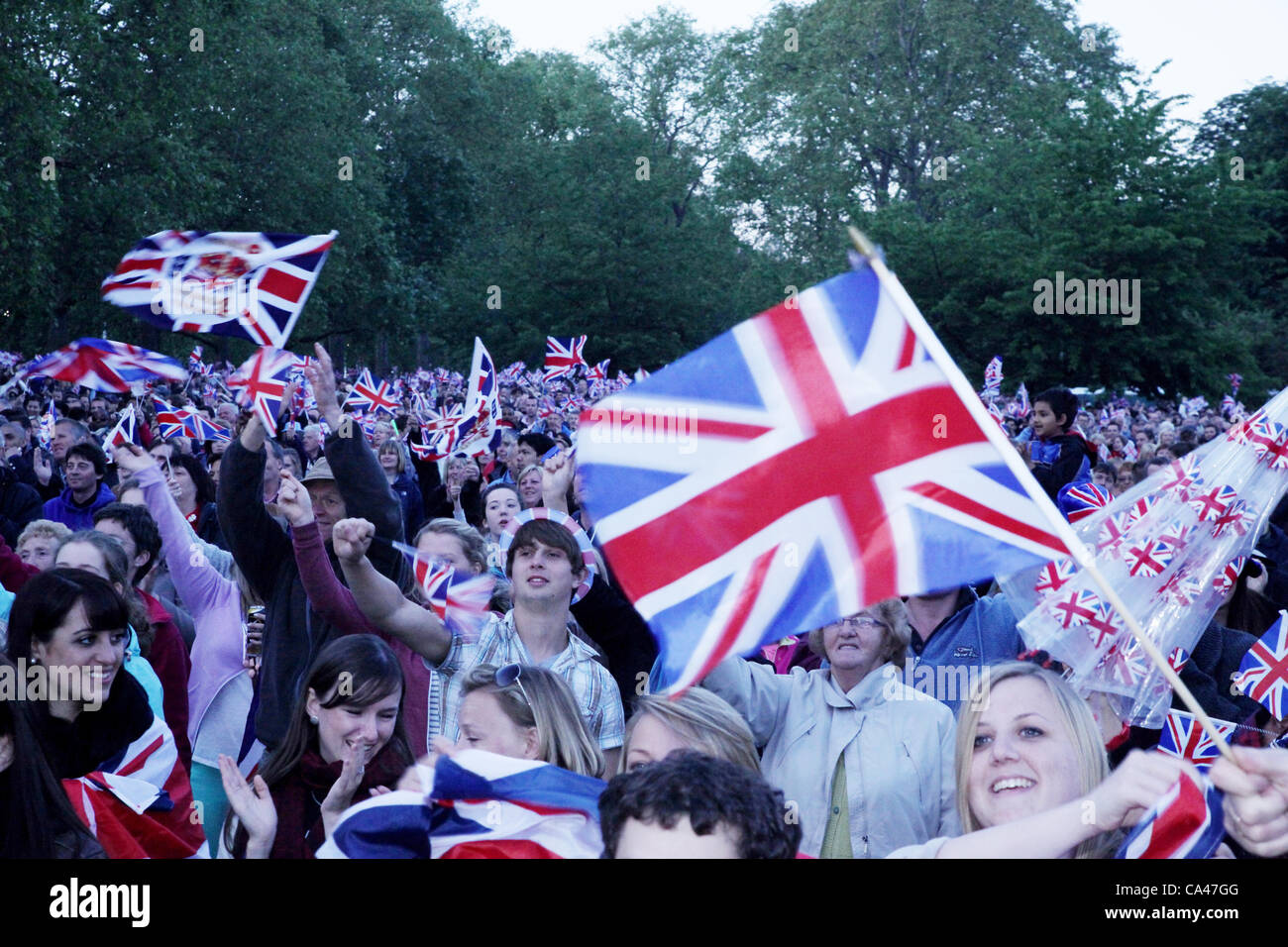 London, UK. June 4, 2012. Fans in of all ages watch and enjoy the Concert to celebrate The Queen's Diamond Jubilee on the big screens in St. james's Park. Stock Photo