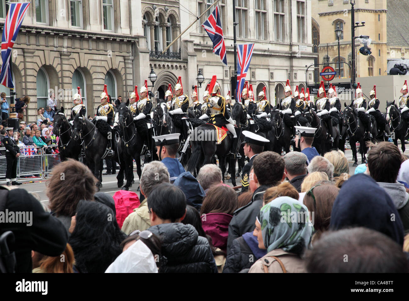 London, UK. June 5, 2012. Crowds line Parliament Street as a The Household Cavalry passes by shortly after leaving Westmister Palace on the occasion of The Queen's Diamond Jubilee. Stock Photo