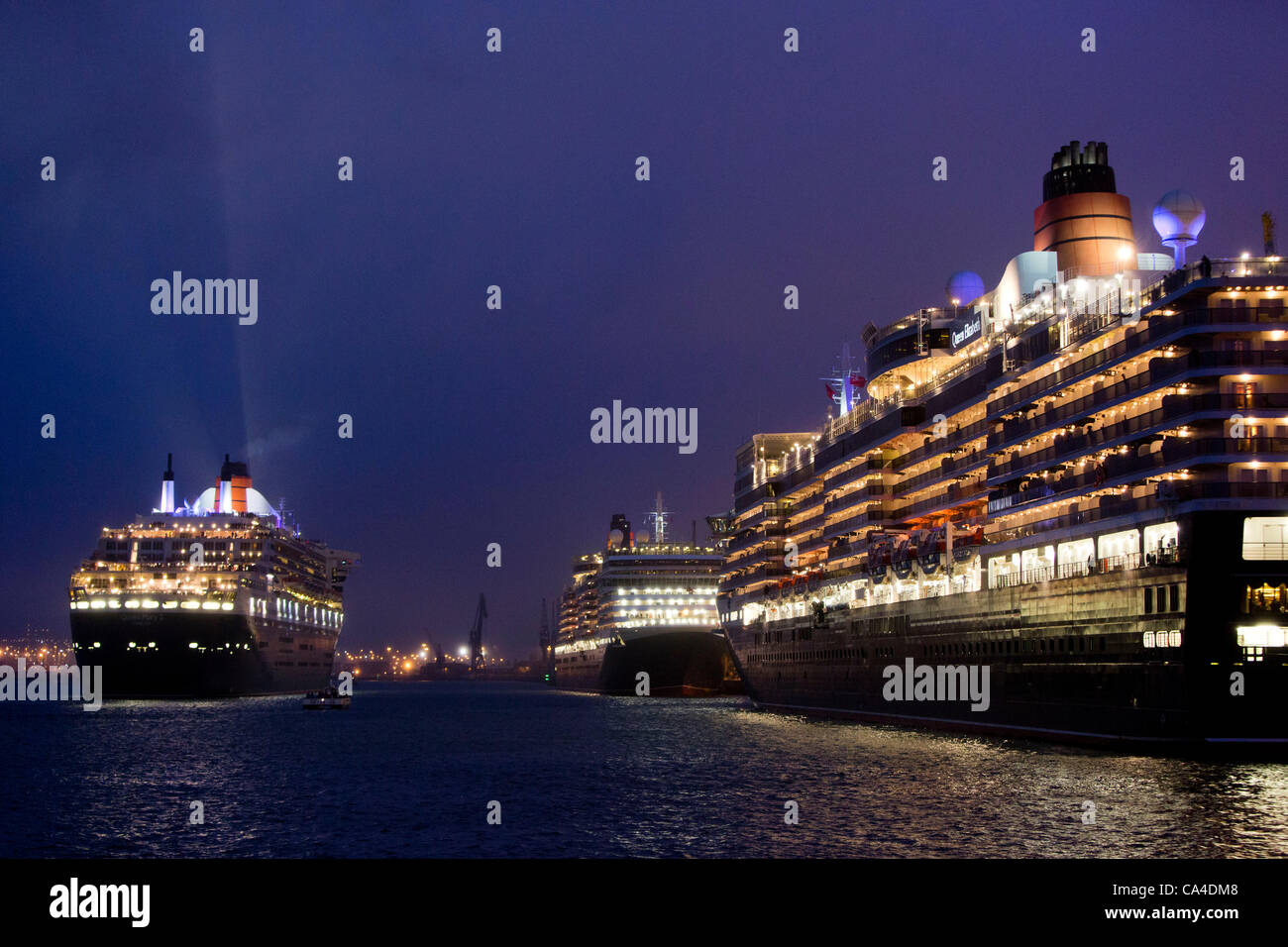 SOUTHAMPTON, UK, 5th June 2012. The Queen Mary 2 (left) Queen Elizabeth (front right) and Queen Victoria (rear right) manouvre in Southampton dock ahead of the Firework Spectacular as part of the 'Three Queens' event during celebrations for Queen Elizabeth II's Diamond Jubilee. Stock Photo
