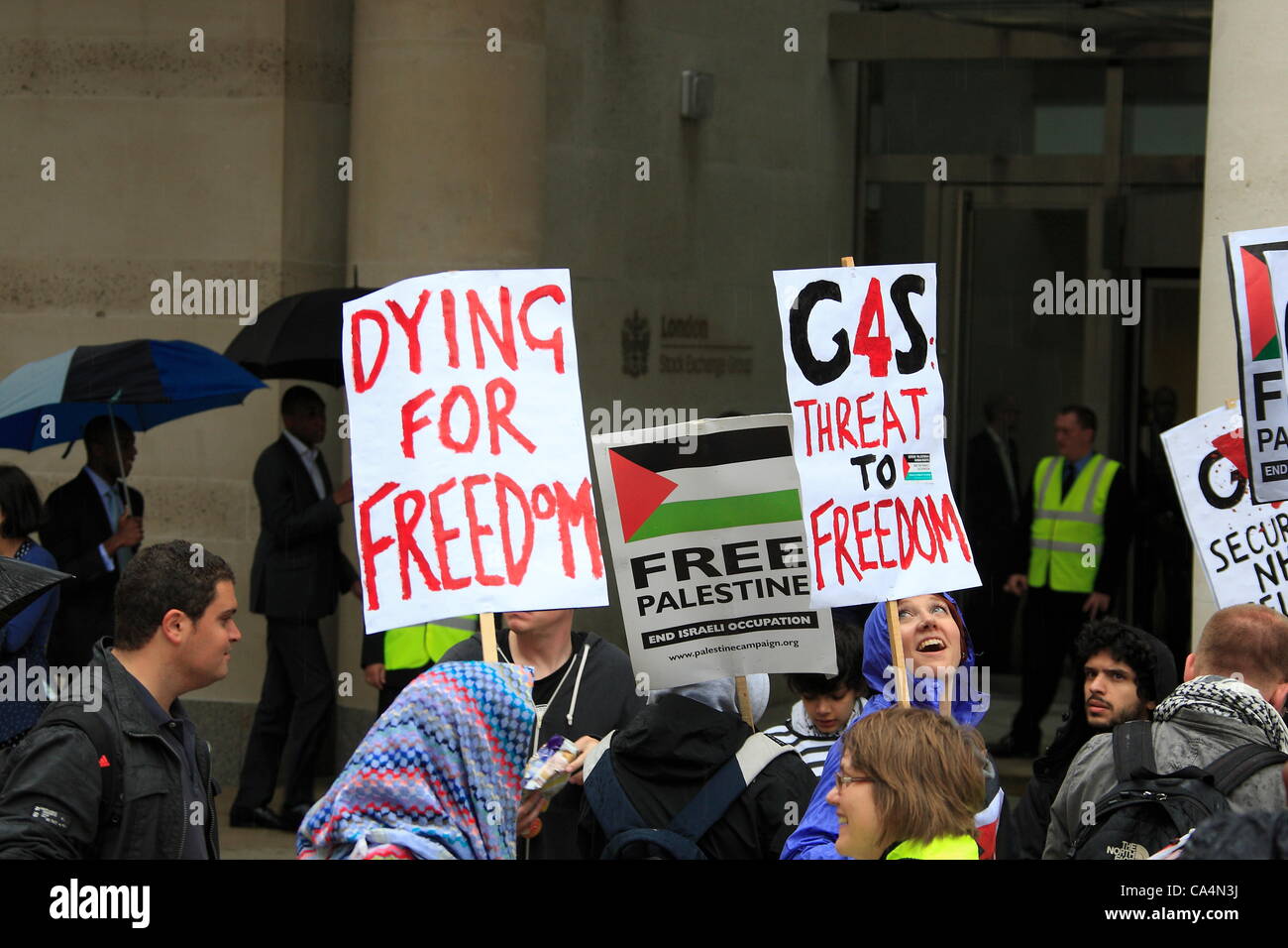 London, UK. 7th June 2012. Protesters with signs. Activists from different movements gathered out side London Stock Exchange, Paternoster Square, London where the private security company 'G4S' held the Annual General Meeting. Protesters accuse G4S of human rights abuse throughout the world. Stock Photo