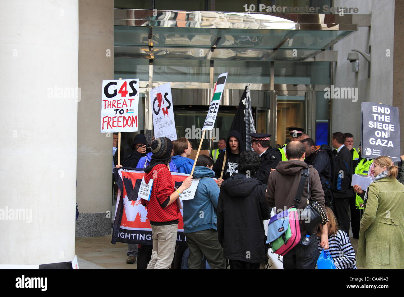 London, UK. 7th June 2012. Protesters with signs. Activists from different movements gathered out side London Stock Exchange, Paternoster Square, London where the private security company 'G4S' held the Annual General Meeting. Protesters accuse G4S of human rights abuse throughout the world. Stock Photo