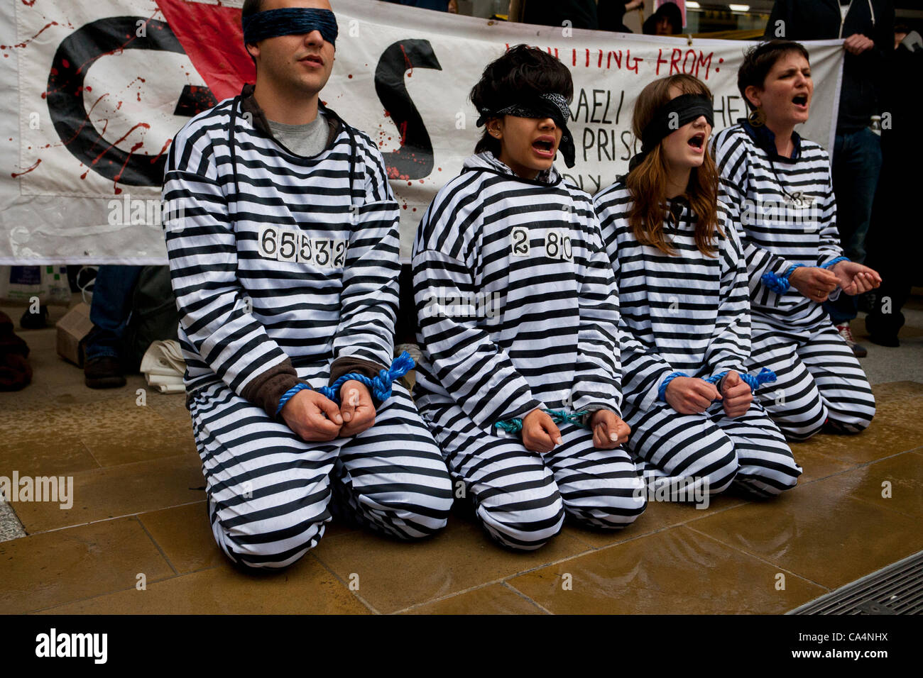 London, UK. 07th June 2012. Activists from different movements dressed as prisoners outside London Stock Exchange, in Paternoster Square where the private security company 'G4S' held the Annual General Meeting. Protesters accuse G4S of human rights abuse throughout the world. Stock Photo