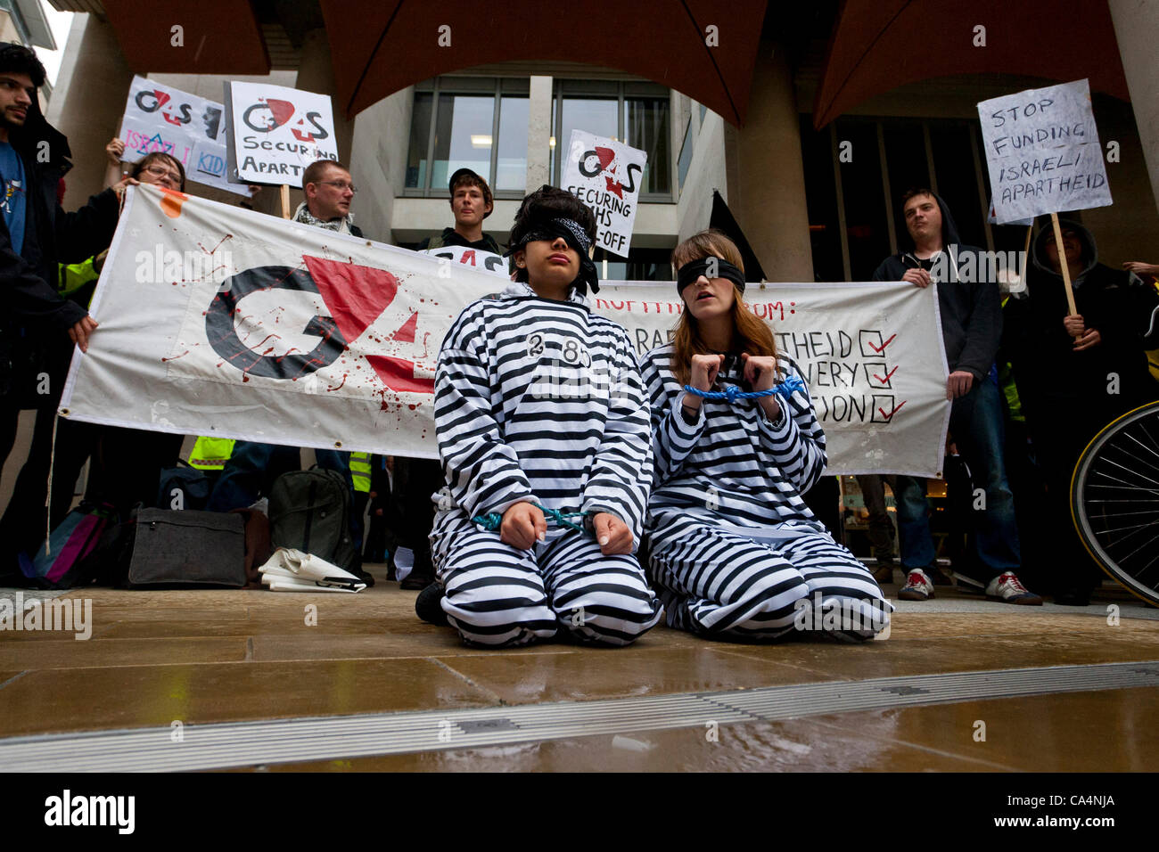 London, UK. 07th June 2012. Activists from different movements dressed as prisoners outside London Stock Exchange, in Paternoster Square where the private security company 'G4S' held the Annual General Meeting. Protesters accuse G4S of human rights abuse throughout the world. Stock Photo