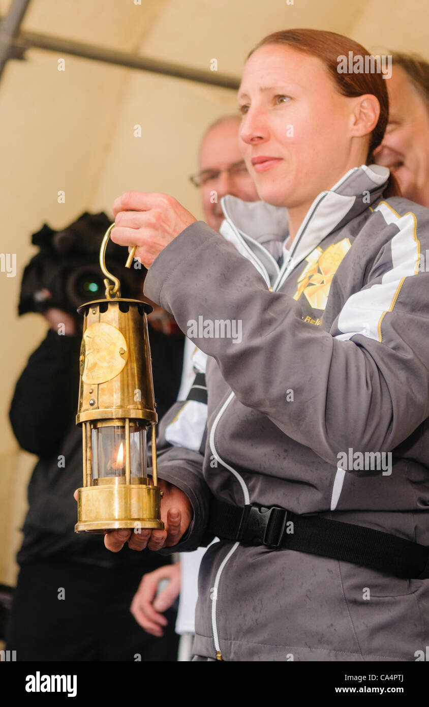 The Olympic Flame in its Davy Lamp lantern is held up Stock Photo