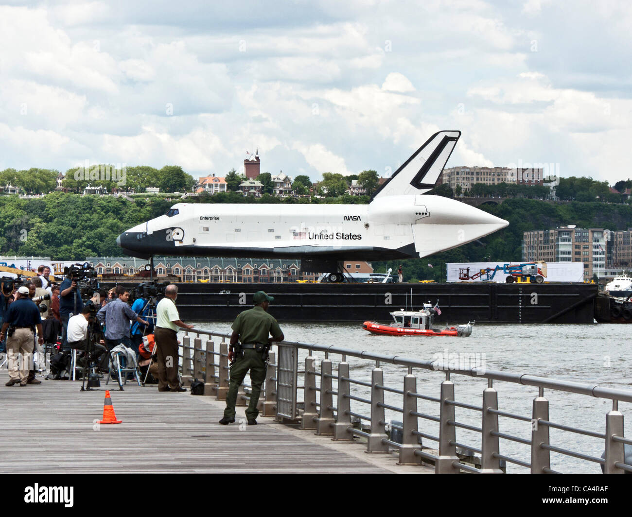 barge carrying space shuttle Enterprise pauses to give press & television cameras a photo op before heading in toward Intrepid Museum berth to complete transfer by crane to ship's flight deck Stock Photo