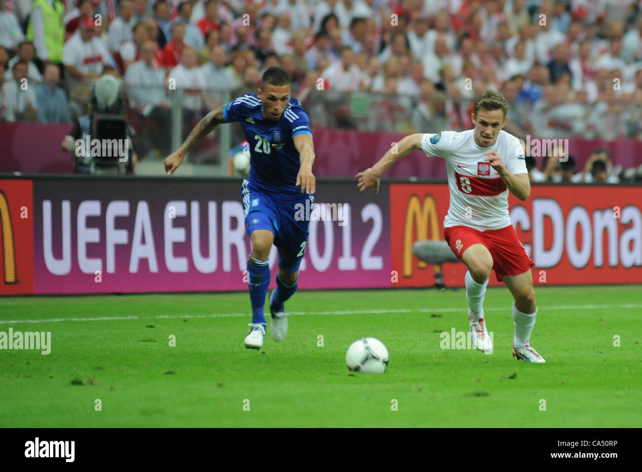 08.06.2012 Warsaw, Poland. Maciej Rybus (FC Terek Grozny)  Poland being tackled by Jose Holebas (Olympiacos FC) during the European Championship Group A game between Poland and Greece from the National Stadium. Stock Photo