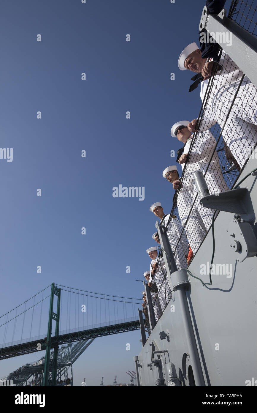 A line of sailors in dress whites aboard the battleship USS Iowa as it passes under the Vincent Thomas Bridge in San Pedro as it makes its final transition underway from Berth 51 to its new home at Berth 87 in Los Angeles, CA where it opens as a museum ship in July 2012. Stock Photo