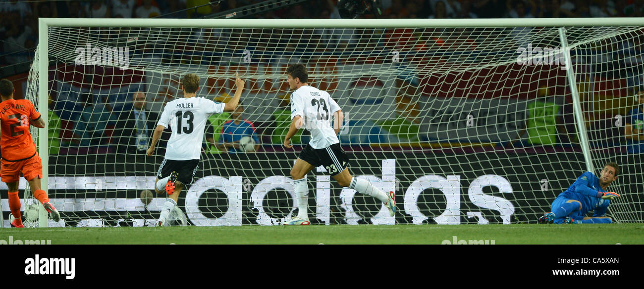 13.06.2012. Kharkiv, Ukraine.  Germany's Mario Gomez (C) scores the goal for 1-0 against Netherland's goalkeeper Maarten Stekelenburg (R) and Gregory van der Wiel (L) as Germany's Thomas Mueller looks on during the UEFA EURO 2012 group B soccer match the Netherlands vs Germany at Metalist Stadium in Stock Photo