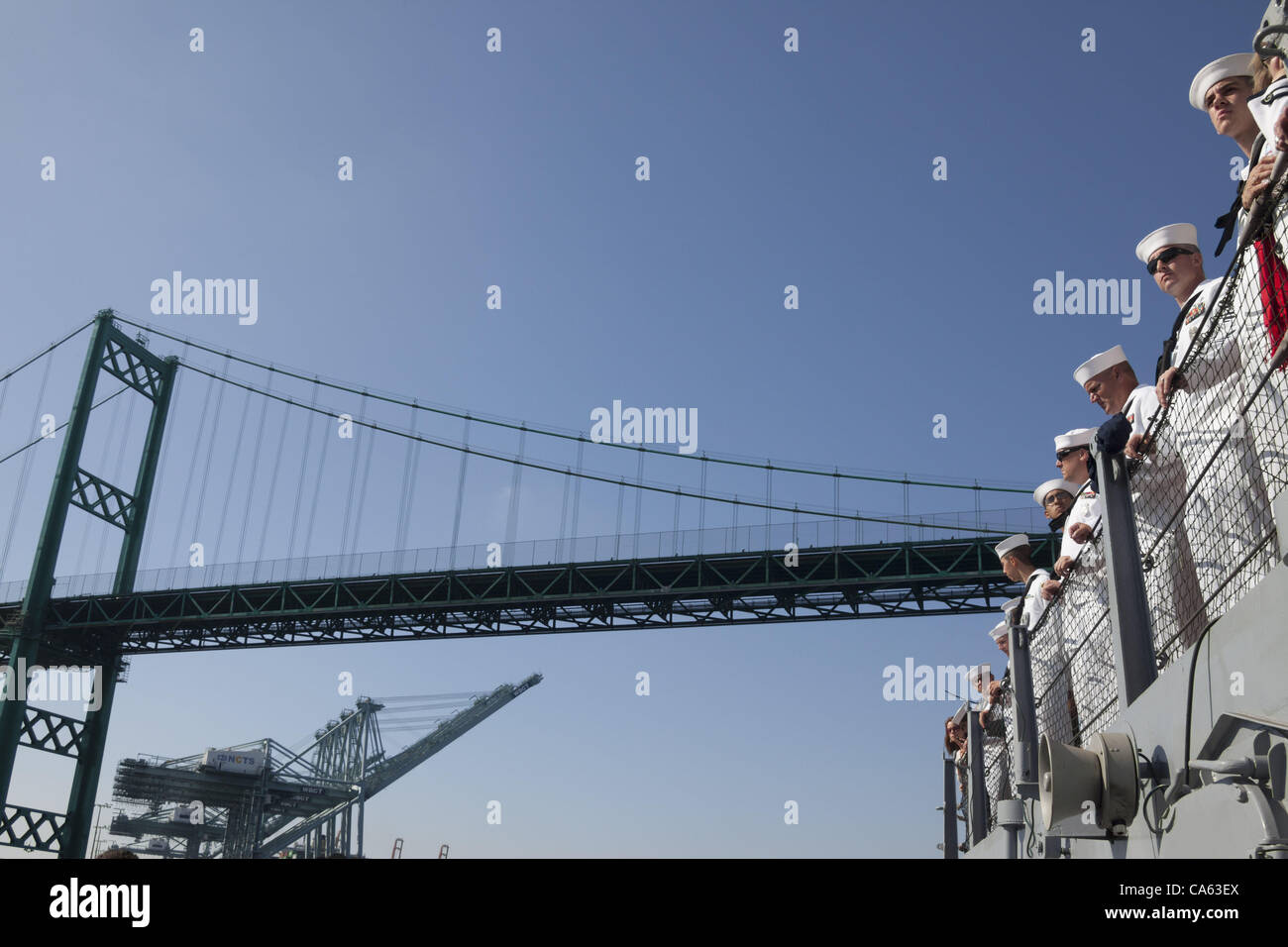 A line of sailors in dress whites aboard the battleship USS Iowa as it passes under the Vincent Thomas Bridge in San Pedro as it makes its final transition underway from Berth 51 to its new home at Berth 87 in Los Angeles, CA where it opens as a museum ship in July 2012. Stock Photo