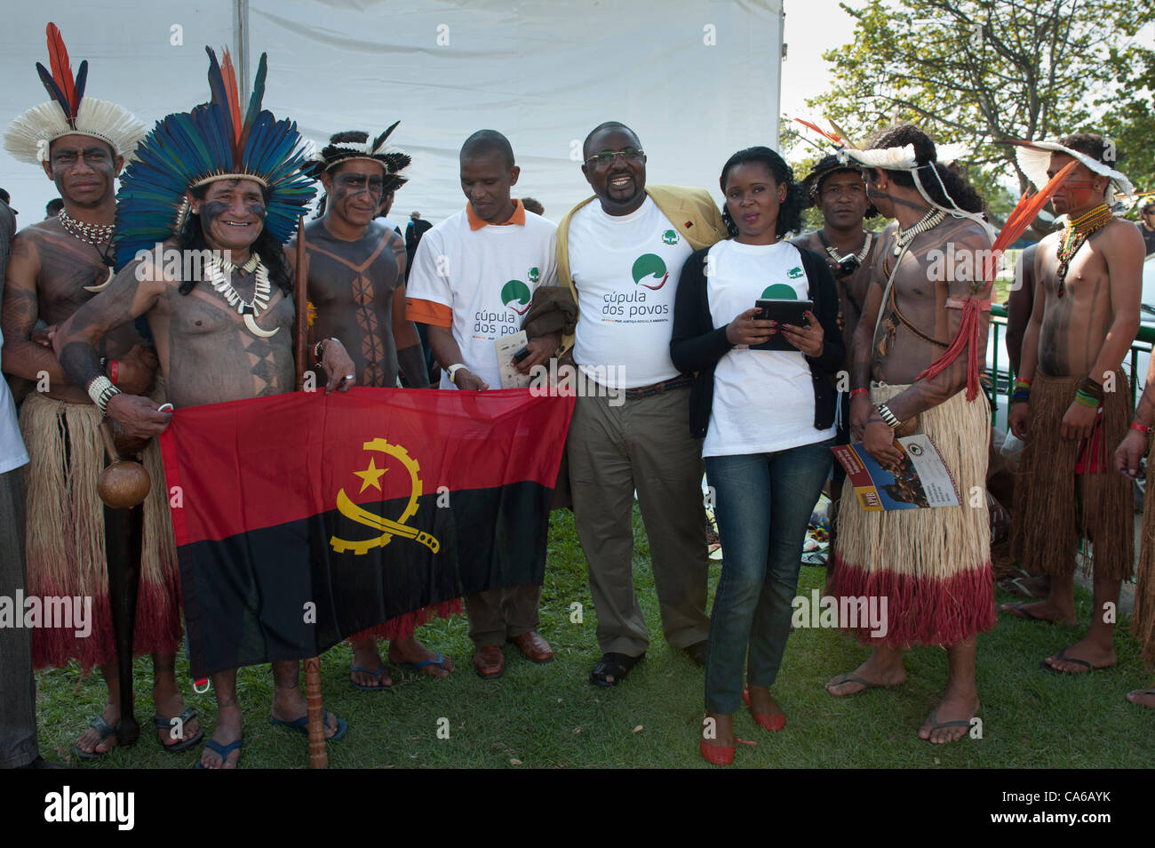 Angolan delegation members pose for a photowith their national flag together with a group of Xukuru Kariri indigenous people from brazil at the People's Summit, United Nations Conference on Sustainable Development (Rio+20), Rio de Janeiro, Brazil, 15th June 2012. Photo © Sue Cunningham. Stock Photo