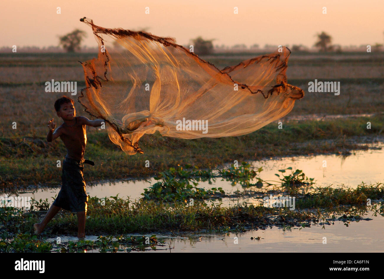 Fisherman throwing fishing net during hi-res stock photography and