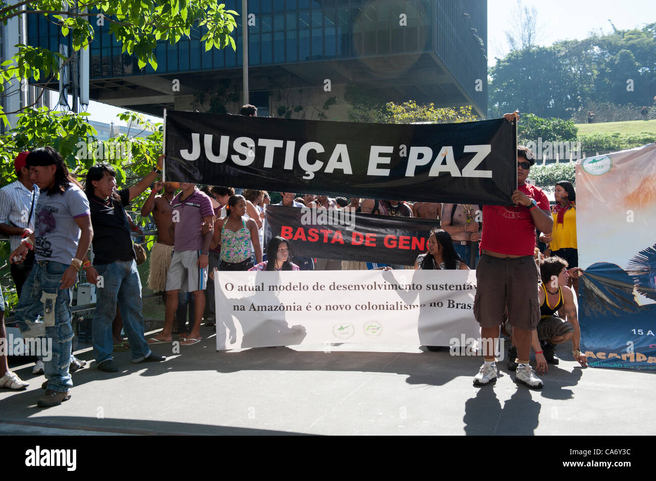 Indigenous people with a banner, 'Justice and Peace', protest outside BNDES, the Brazilian Development Bank, after marching from the People's Summit at the United Nations Conference on Sustainable Development (Rio+20), Rio de Janeiro, Brazil, 18th June 2012. Photo © Sue Cunningham. Stock Photo