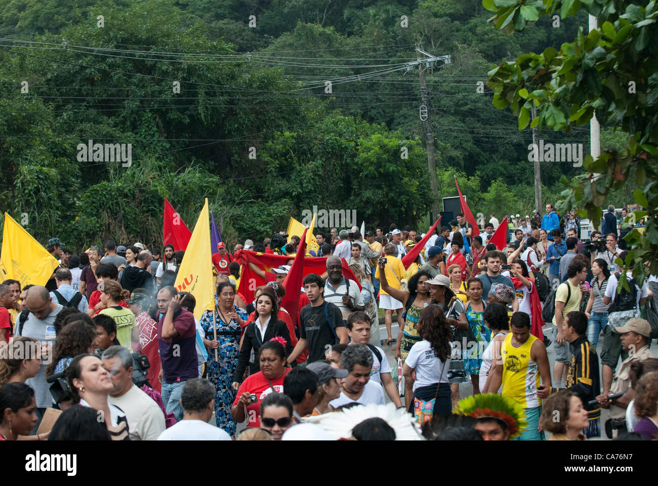 Rio de Janeiro, Brazil, 20th June 2012. A mass of demonstrators wave flags and banners during a demonstration by indigenous people, the Landless People's Movement (MST) and other civil society groups in front of the Riocentro United Nations conference. The demonstrators are kept out of earshot and invisible to the UN conference. The United Nations Conference on Sustainable Development (Rio+20), Rio de Janeiro, Brazil, 20th June 2012. Photo © Sue Cunningham. Stock Photo