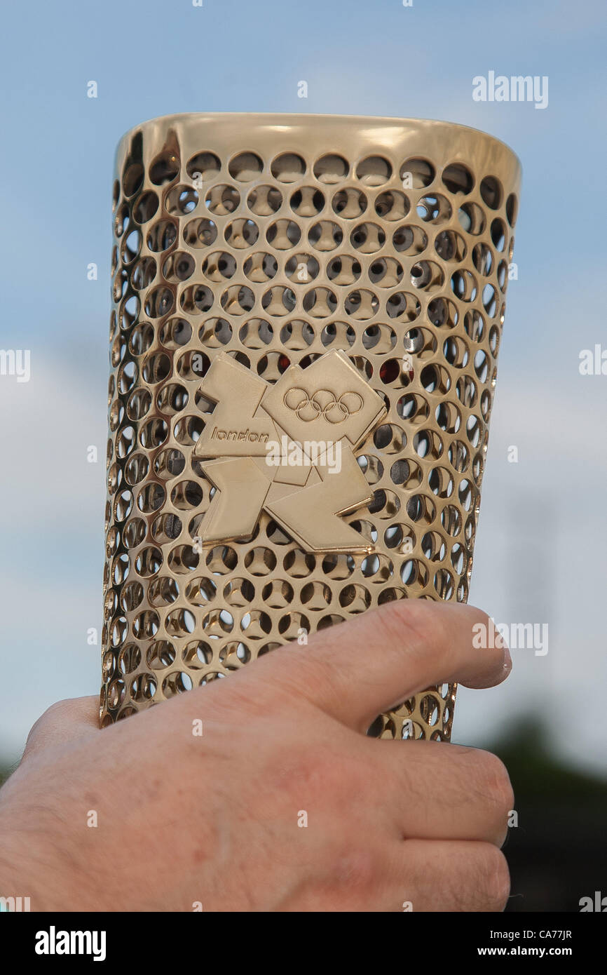 A London 2012 Olympic Relay Torch in closeup, held by a man's hand