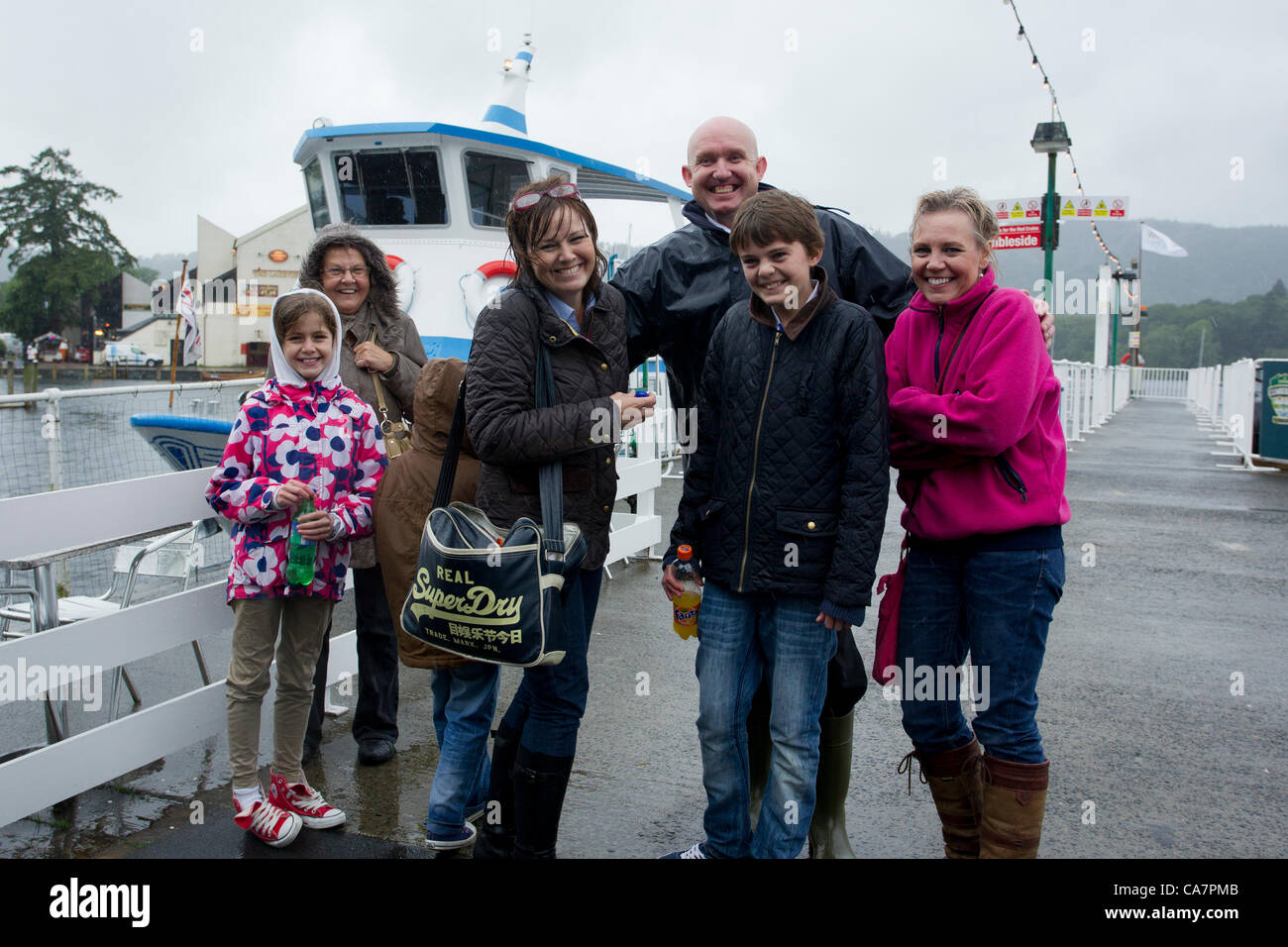 Saturday 23rd June -Windermere Cumbria UK  Swimmers from the canceled Great North Swim  making the most of a family day out in the rain with the Pier Manager  before goring for a cruise to keep dry Stock Photo