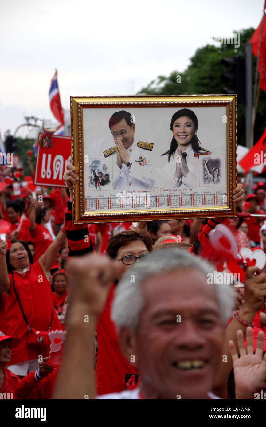 Bangkok , Thailand,  June 24, 2012 .'Red Shirt' holding portrait with an image of ousted Thai prime minister Thaksin Shinawatra (pictured L) and his sister, current Prime Minister Yingluck Shinawatra during gather at Democracy Monument to mark the 80th anniversary of the June 24, 1932 coup. Thailand has been a constitutional monarchy with a parliamentary government since a bloodless coup on June 24, 1932 overthrew the absolute monarchy. Stock Photo