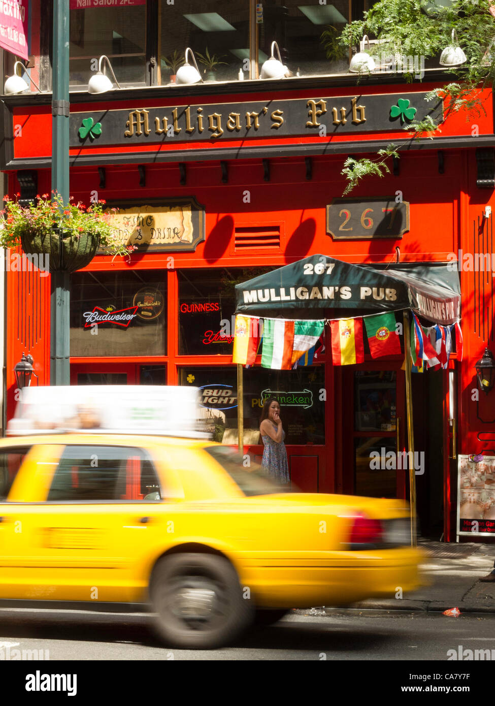 New York City, USA. 24th June 2012.   The UEFA EURO 2012 broadcasts have extended pub hours to accommodate the world time zone differences.  Mulligan's flag display indicates that the tournament is featured on their electronic displays. Stock Photo