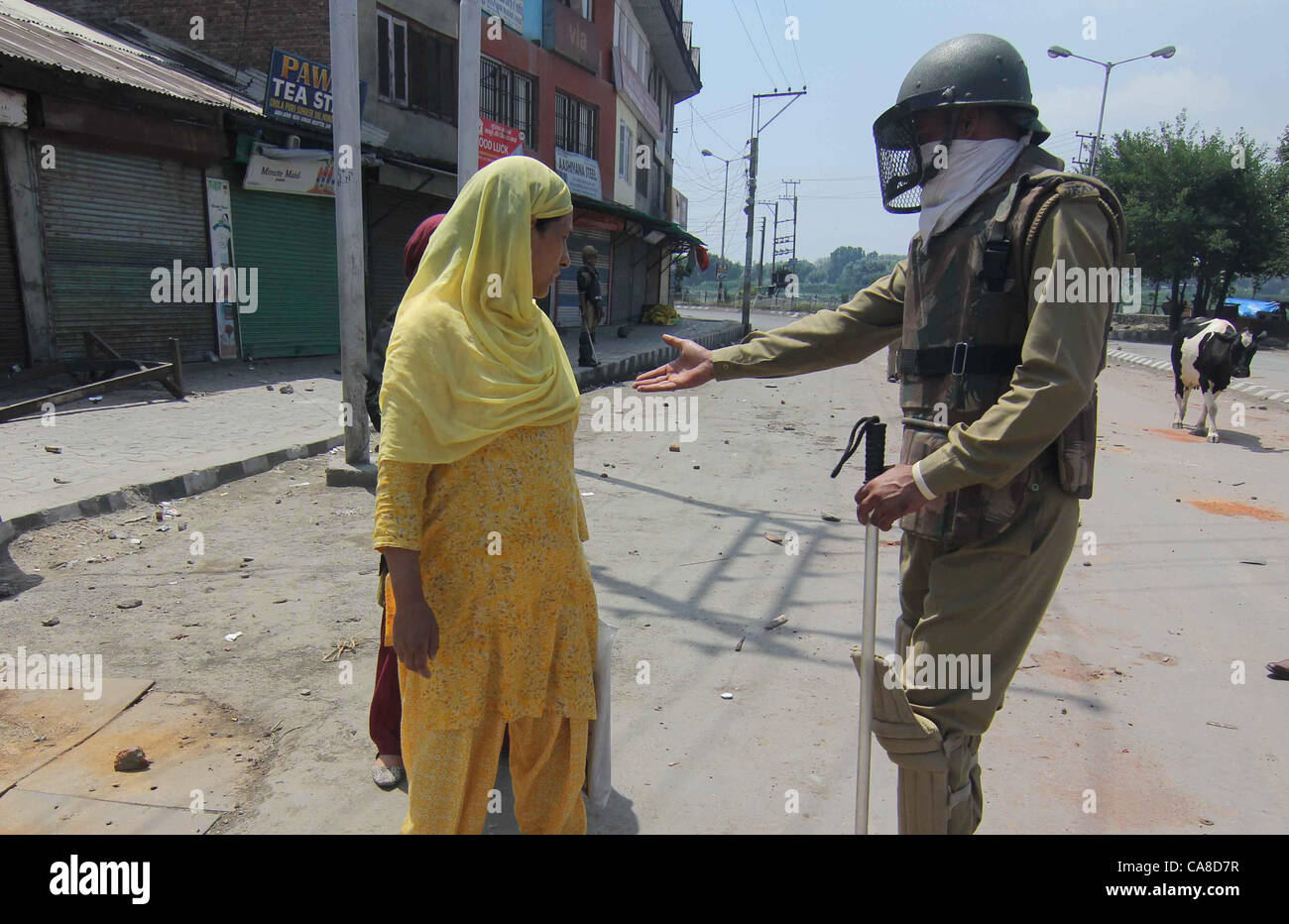An Indian police questioning a Kashmiri Muslim woman during a curfew in downtown area of Srinagr, the summer capital of Indian Kashmir, 26, June, 2012,Undeclared curfew-like restrictions were imposed in the old city areas of Srinagar Tuesday following tension in the city over the gutting of the revered shrine of Sheikh Abdul Qadir Jeelani in the Khanyar area.Although no official announcement to this effect was made, police and paramilitary Central Reserve Police Force (CRPF) deployed in riot control gear disallowed pedestrian and vehicular movement in old city areas falling under the Khanyar,  Stock Photo