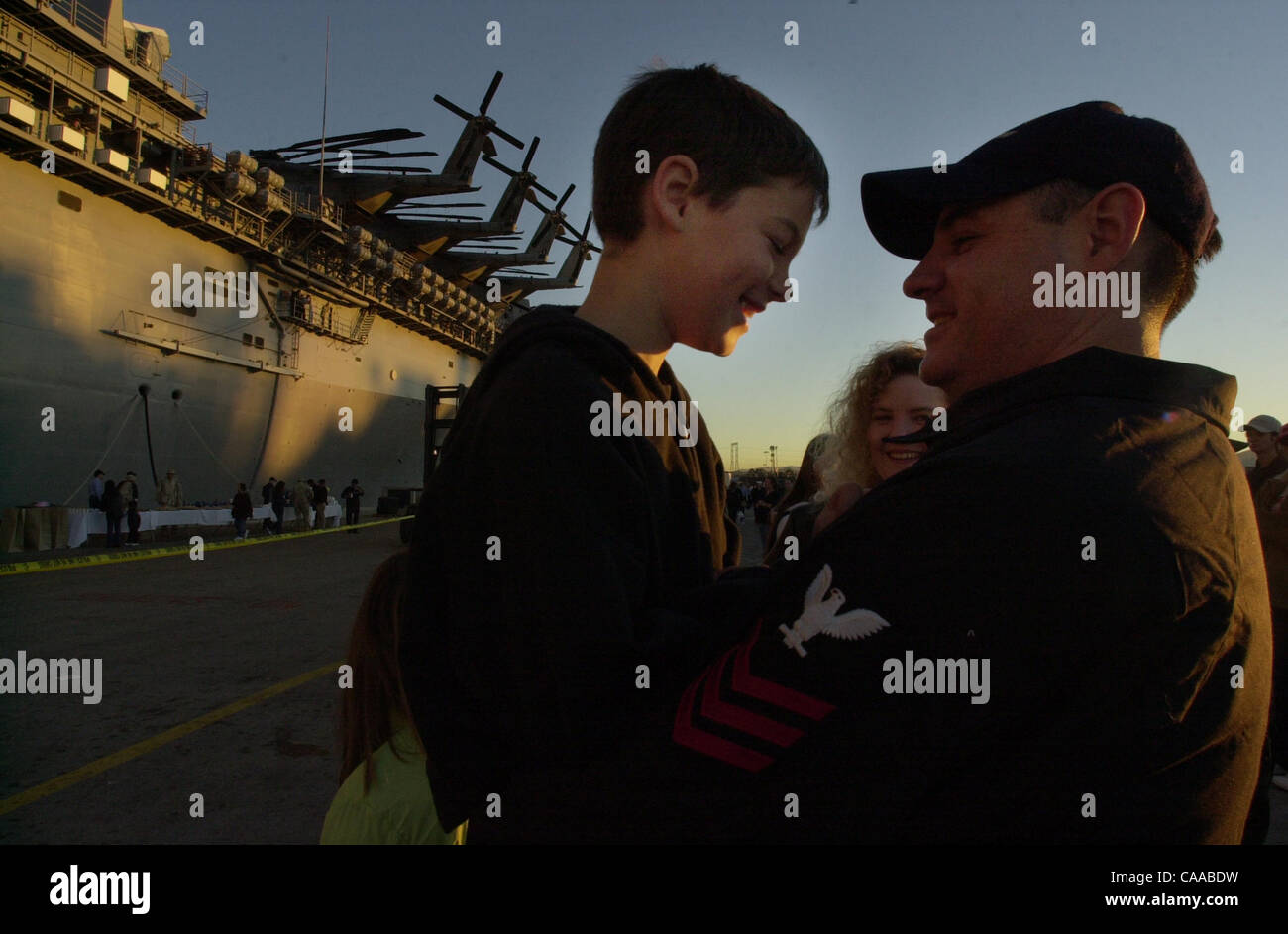 (PUBLISHED 01/18/2003, A-18): IT1 Albert Crain hoists his son Jared, 8, to eye level so he can say goodbye while the sun rises behind them alongside the USS Boxer Friday morning at the 32nd Street Naval Station. Peggy Peattie photo Stock Photo