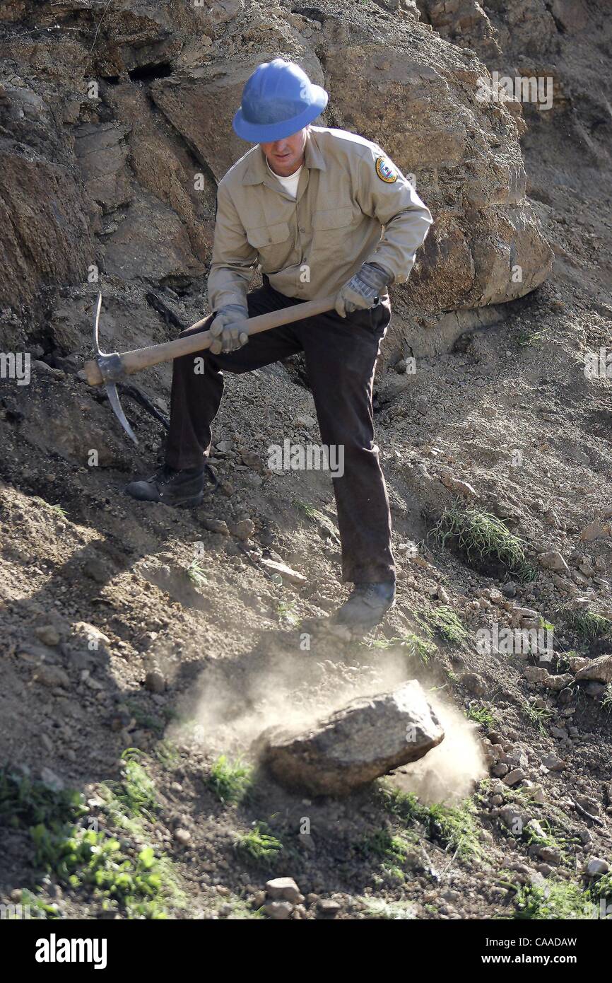 (Published on 12/23/2004, B-1:2,7; UTS1851880) SLgoodanranch232770x001/Dec 22---California Conservation Corp member John Williams uses a pick axe to loosen chunks of granite to be used for a erosion control rock drainage culvert at Sycamore Canyon/Goodan Ranch Open Space Preserve in Poway.  Photo/Sc Stock Photo