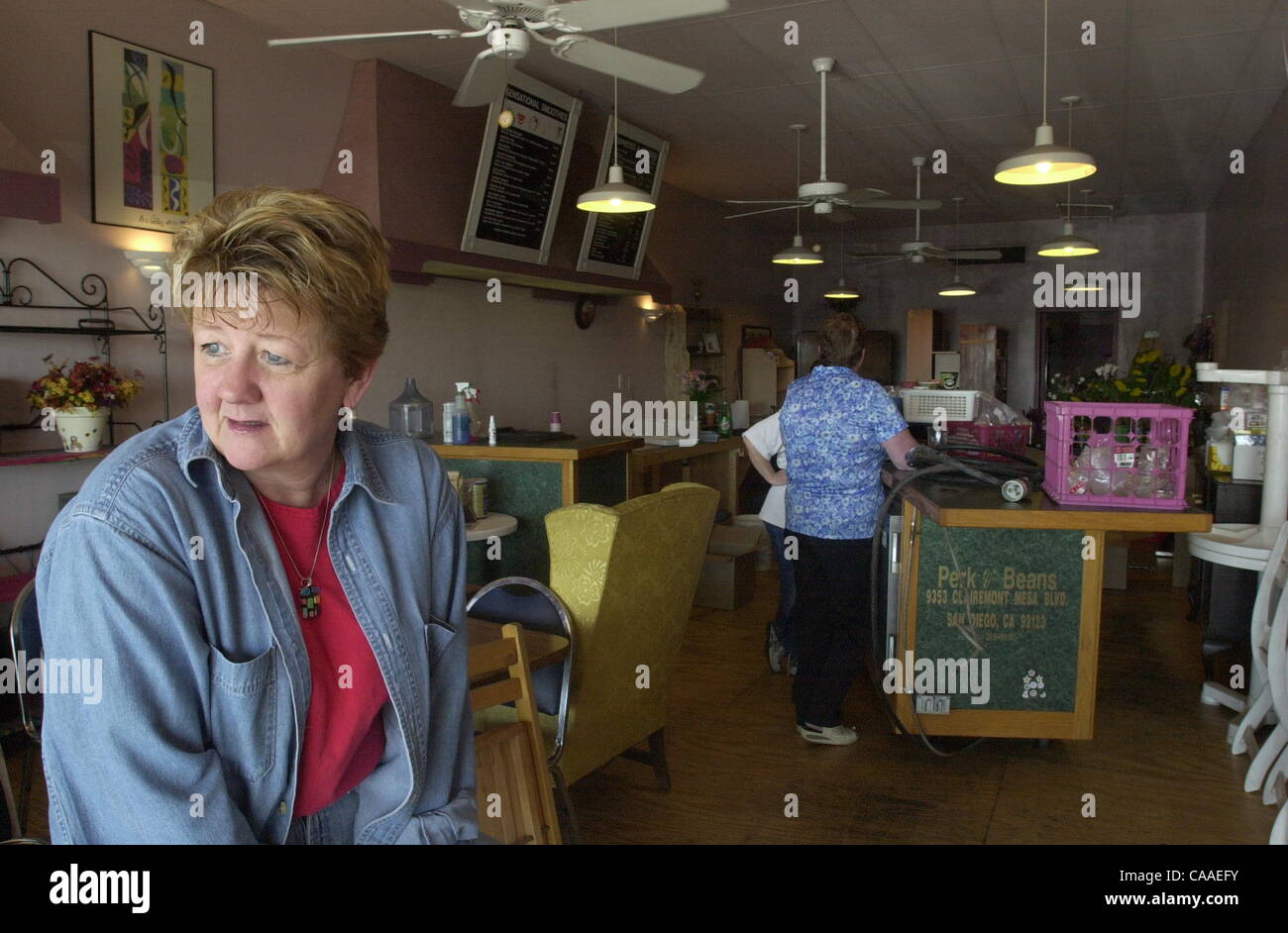 (Published 02/03/2004, E-1:1,7, UTS1786944) Sally Winter gazes outthe window of her former Del Cerro coffeehouse, Perk & Beans, as friends help clean up the ruins. Skyrocketing rent is causing the closure of the 6 1/2 year old neighborhood treasure. The last weekend it was open over 300 people stopp Stock Photo