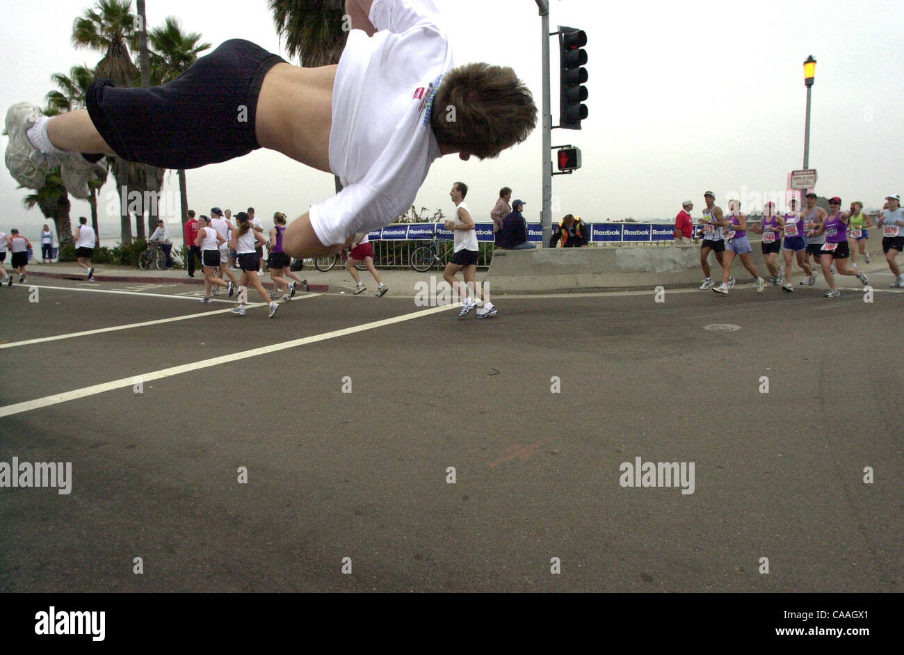 (Published 06/02/2003, E-16) Shane Taylor, captain of the varsity cheerleading team at West Hills High School, does a full-twisting back flip to inspire Suzuki Rock n Roll Marathon runners as they round the curve from Ingraham Street onto Crown Point Drive.--Laura Embry/Union-Tribune Stock Photo