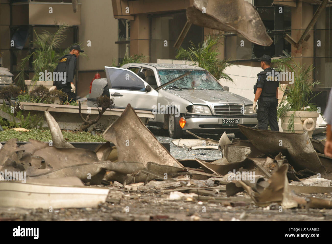 JAKARTA, INDONESIA AUGUST 5, 2003:  Police investigators scrutinize a Mercedes sedan that was parked in the loby area during the explosion at the JW Marriott Hotel.  The explosion damage its lobby, restaurant and nearby buildings.  A car bomb located in front of the loby of Jakarta's JW Marriott hot Stock Photo