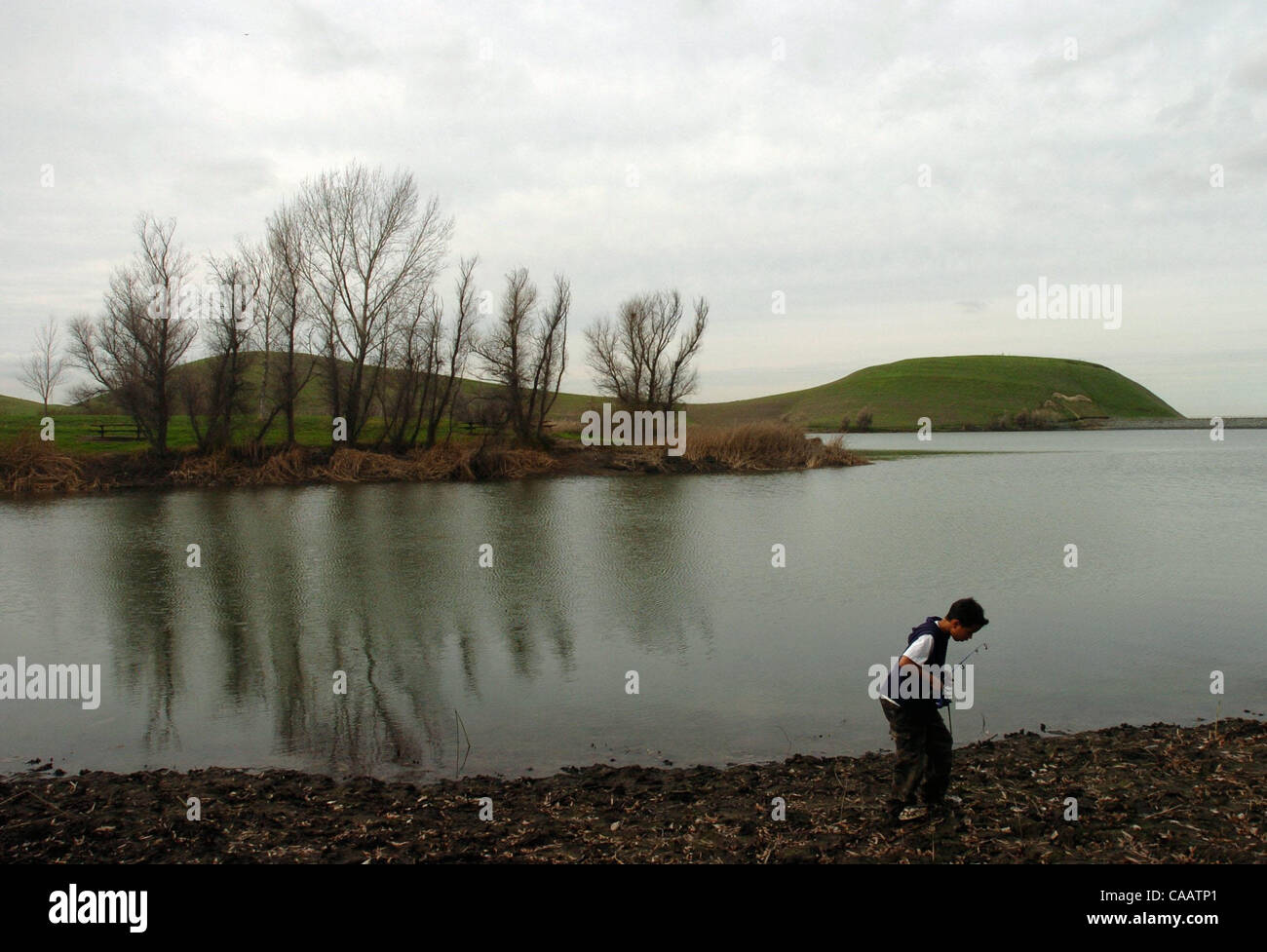 Dayton Fonseca III, 10, of Antioch, walks away from Contra Loma Reservoir after fishing in Antioch, Calif., on Thursday, February 19, 2004. The Contra Costa Water District is studying the possibility of raising the water level at the reservoir. Parks district officials express concern that doing so  Stock Photo