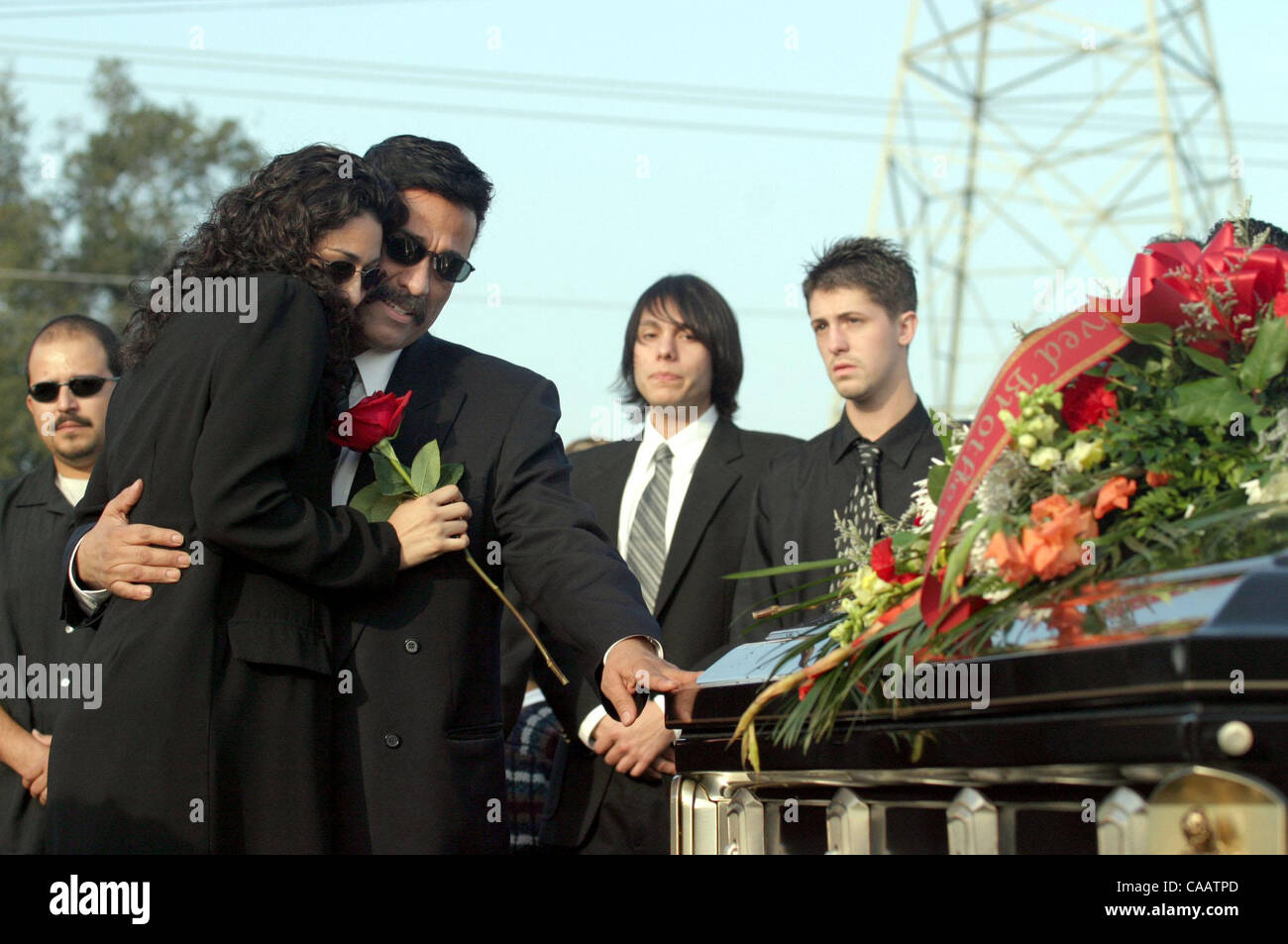 Raquel Orozco cq (left) and her dad Gilbert Orozco hug near the casket of Christopher Armstrong during funeral services for Christopher, who was 24 years-old, and his mother Mary Helen Armstrong at Holy Cross Cemetery in Antioch, Calif. on Thursday, January 29, 2004. Gilbert Orozco is Mary Armstrong Stock Photo